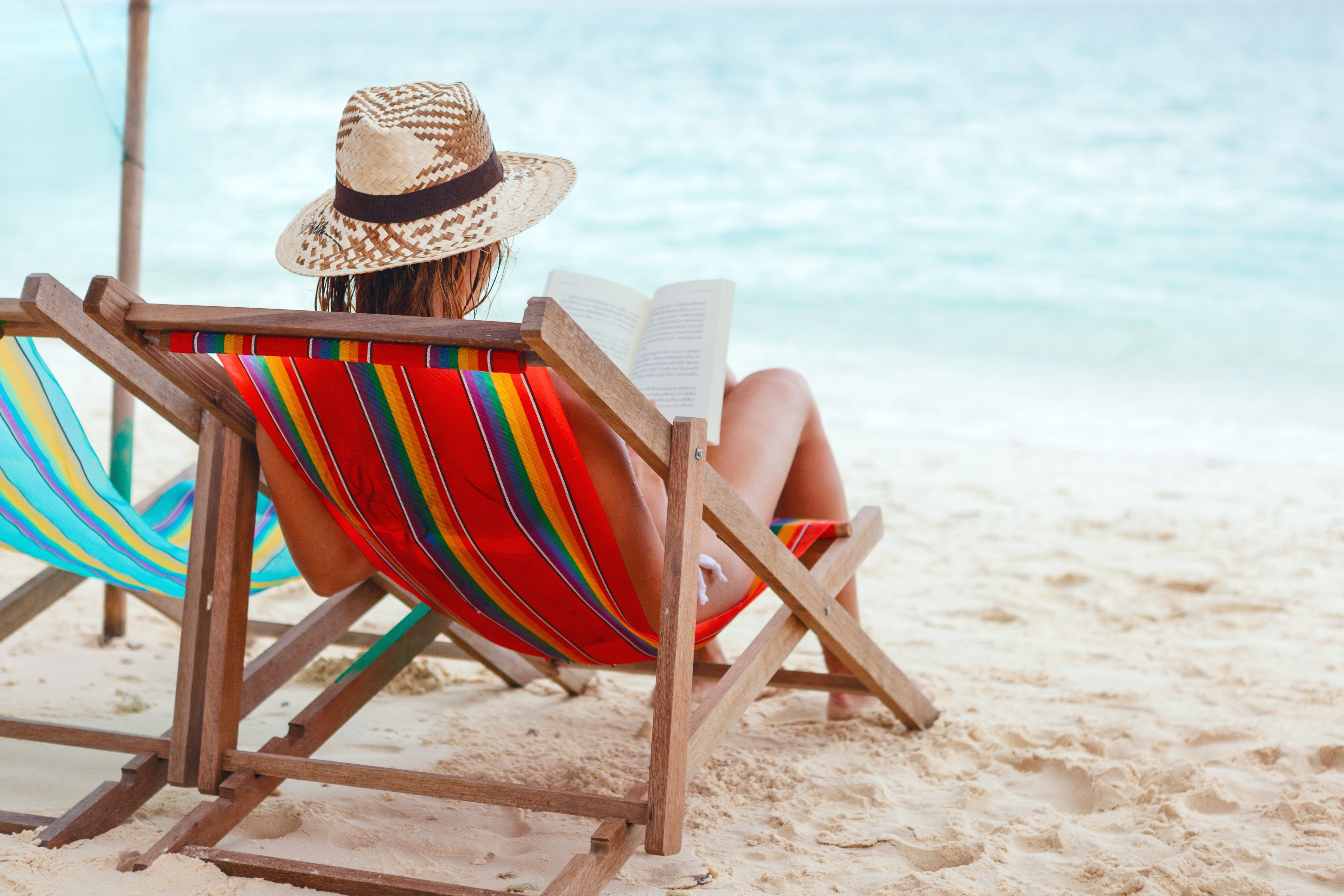 Karen was sitting at the beach reading when she noticed Patricia sitting nearby. | Source: Shutterstock