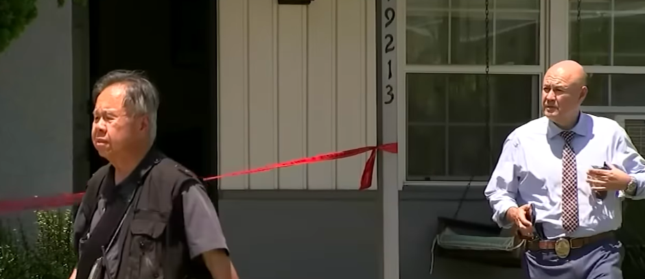A police official and someone else walking from the residence where James Handy was found unresponsive in the yard after the suspect signaled to police and confessed to him being the one they were looking for. | Source: YouTube/ABC7