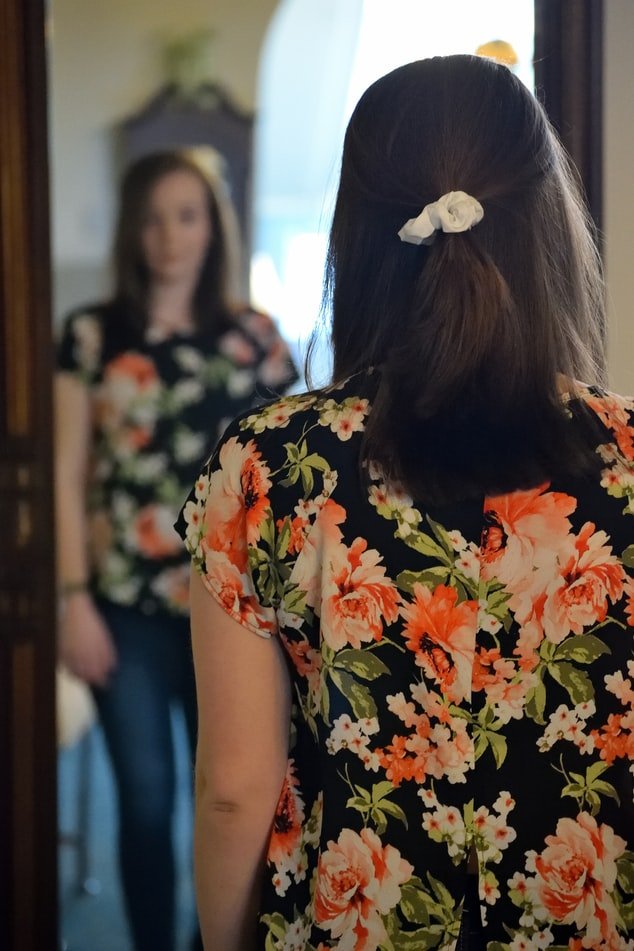 Woman looking at herself in the mirror | Source: Unsplash