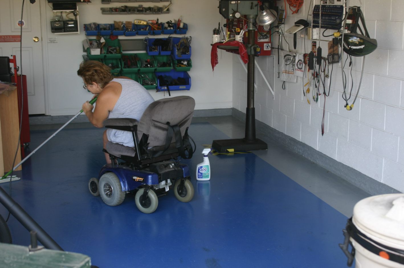 Woman in a wheelchair cleaning the floor. | Source: Flickr