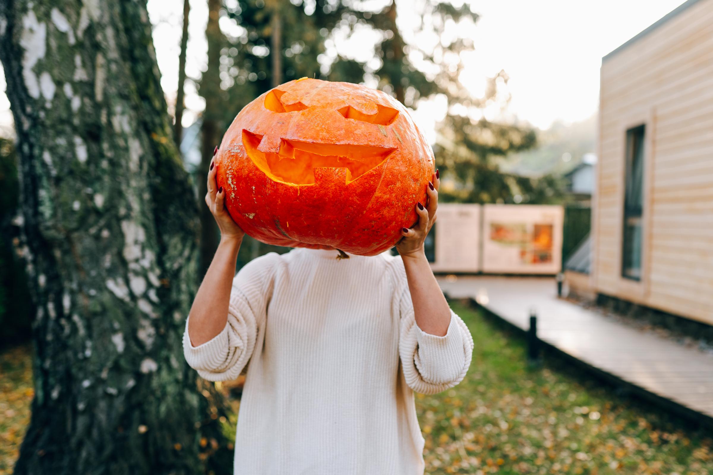 A woman holding her pumpkin in front of her face | Source: Getty Images