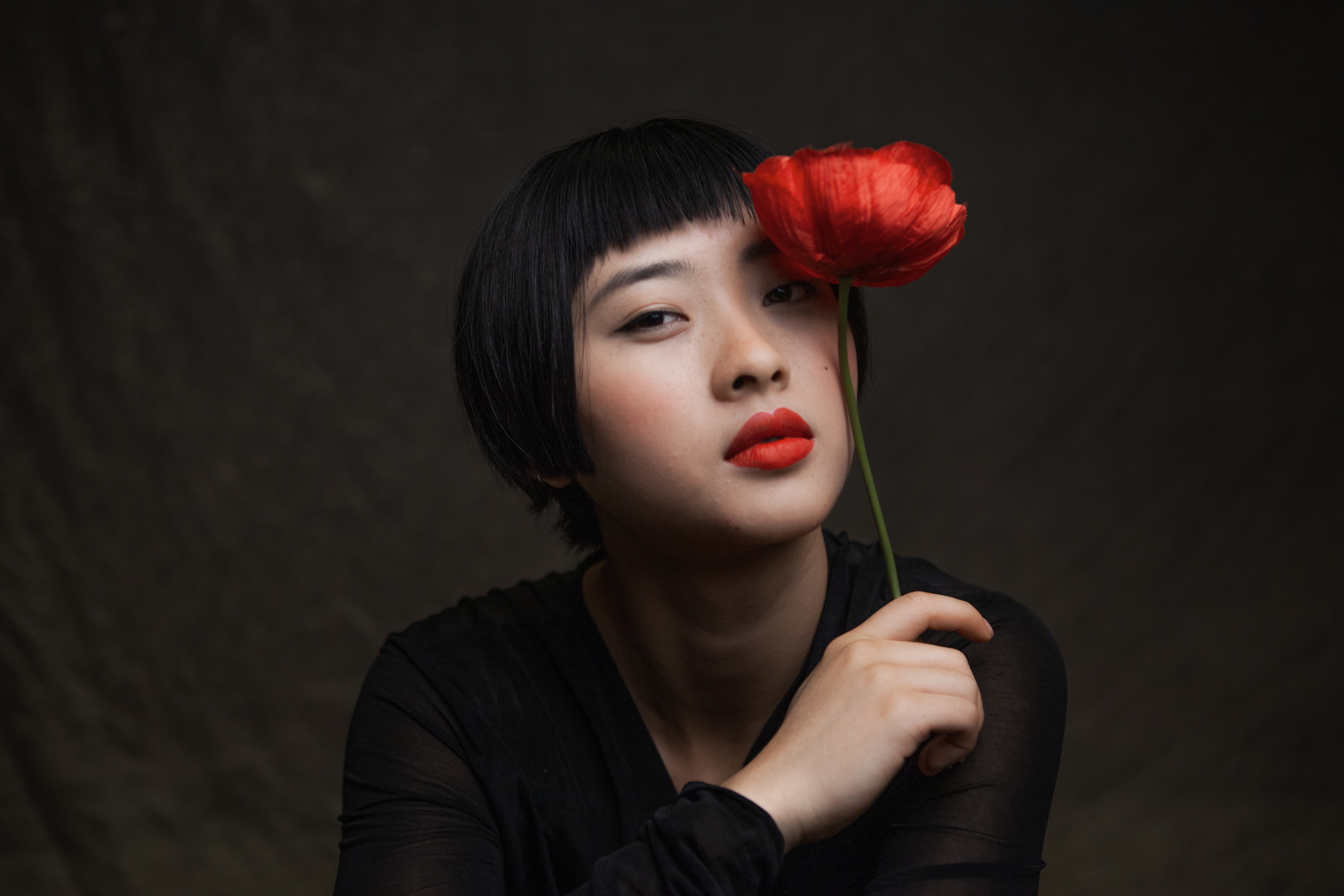 A woman holding a red rose.  | Source: Pexels