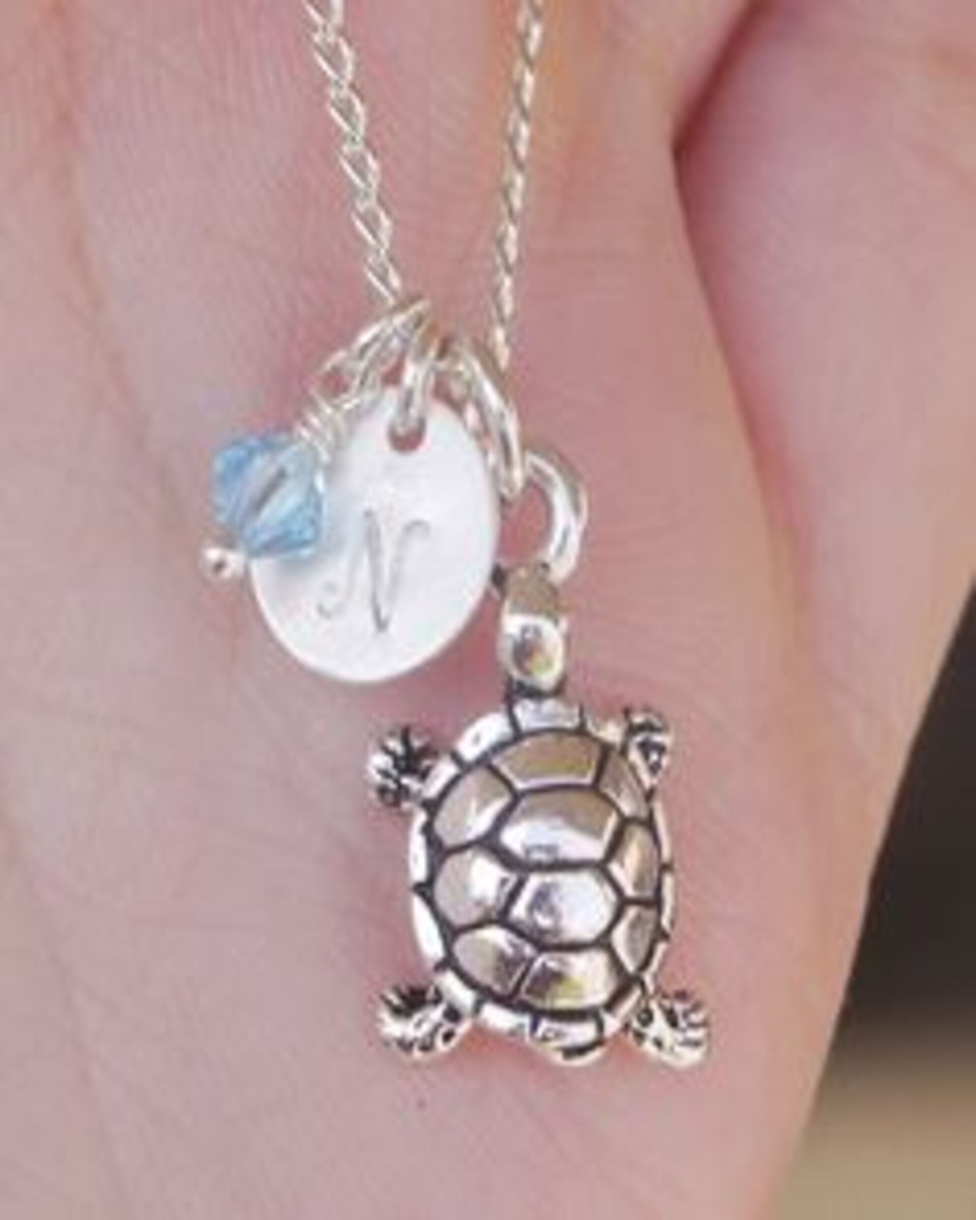 A tortoise necklace with the initial "N" | Source: Flickr