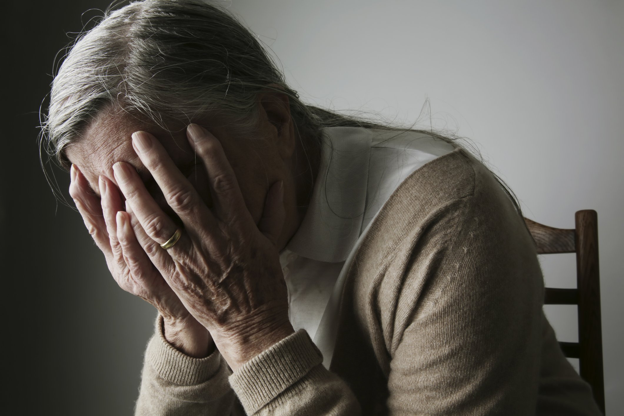 Eine ältere Frau bedeckt ihr Gesicht mit den Händen. I Quelle: Getty Images