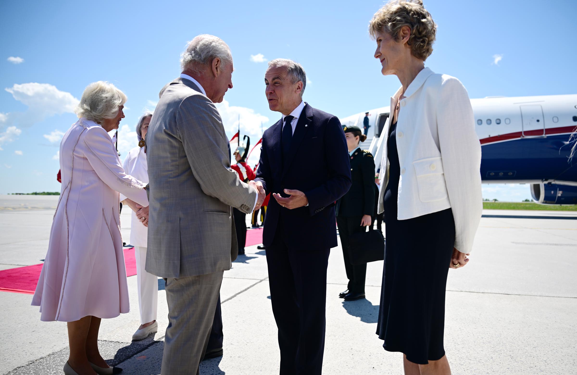 King Charles III and Queen Camilla are warmly greeted by Canadian Prime Minister Mark Carney and Diana Fox Carney, exchanging handshakes and friendly conversation.