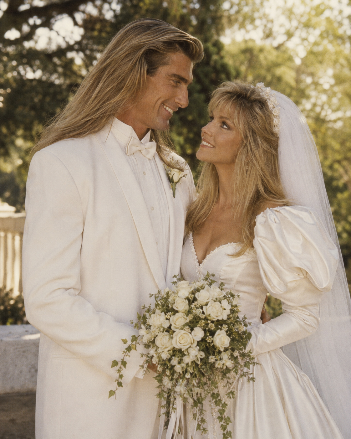 This AI creation captures Fabio in a white tuxedo gazing softly at Heather Locklear in an off-the-shoulder puff-sleeve wedding dress, embodying a lavish late 1980s bridal aesthetic. | Source: ChatGPT