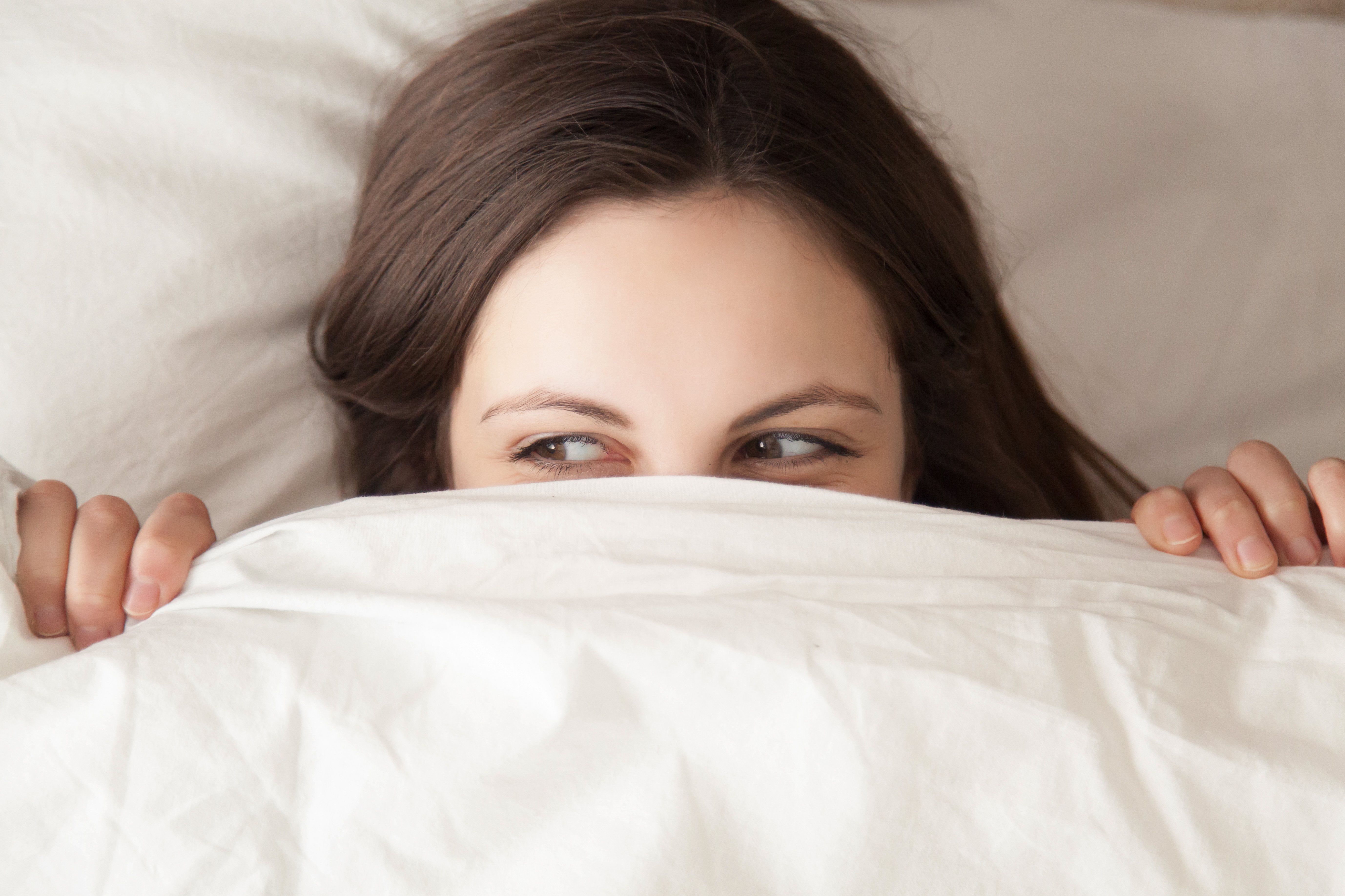 Shy lady hiding under duvet | Photo : Shutterstock Shy lady hiding under duvet | Photo : Shutterstock
