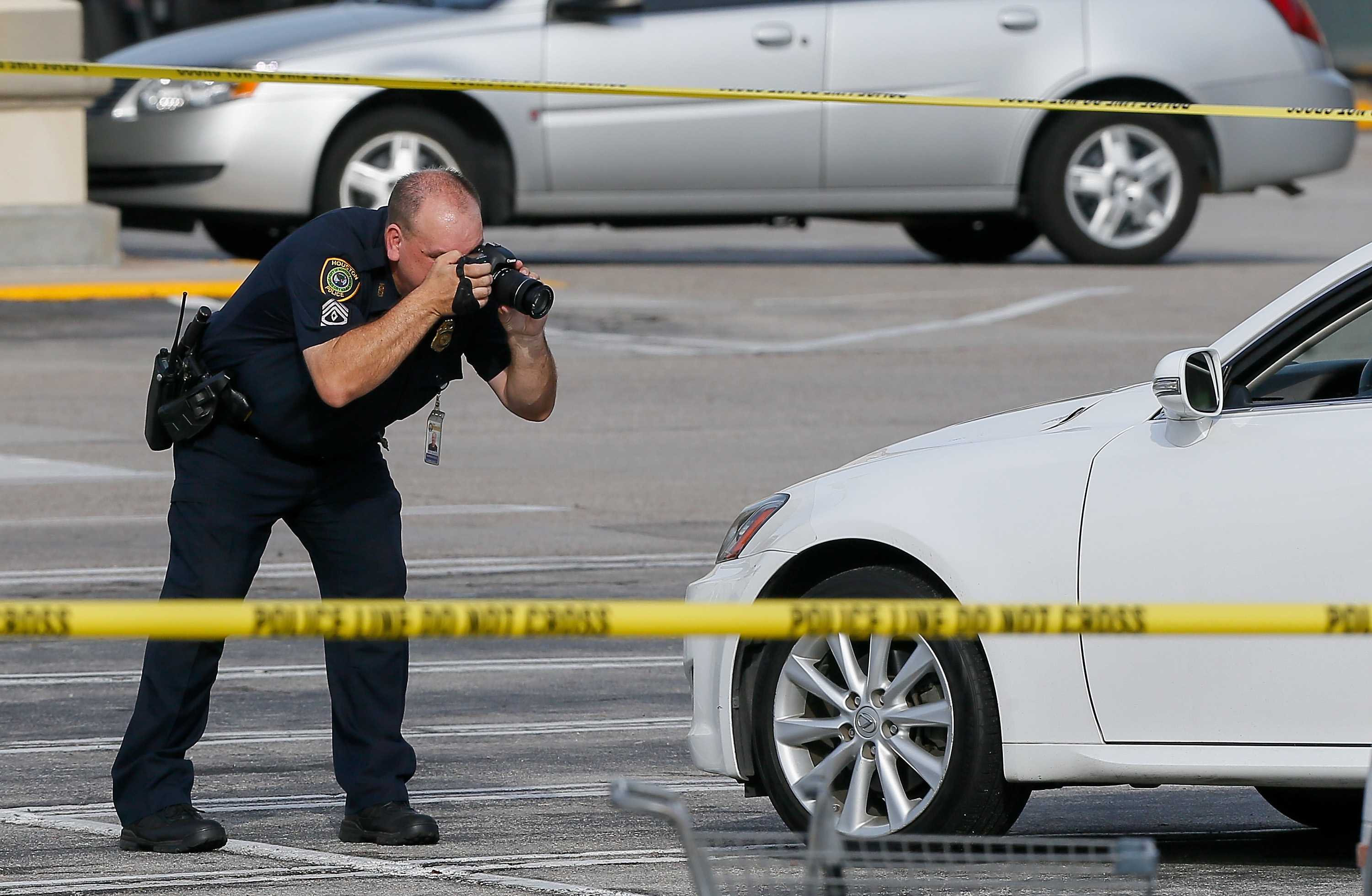 Houston Police investigators photograph a vehicle that received gunshot damage during a scene where nine were wounded in a strip mall shooting in Houston, Texas, on September 26, 2016 | Source: Getty Images