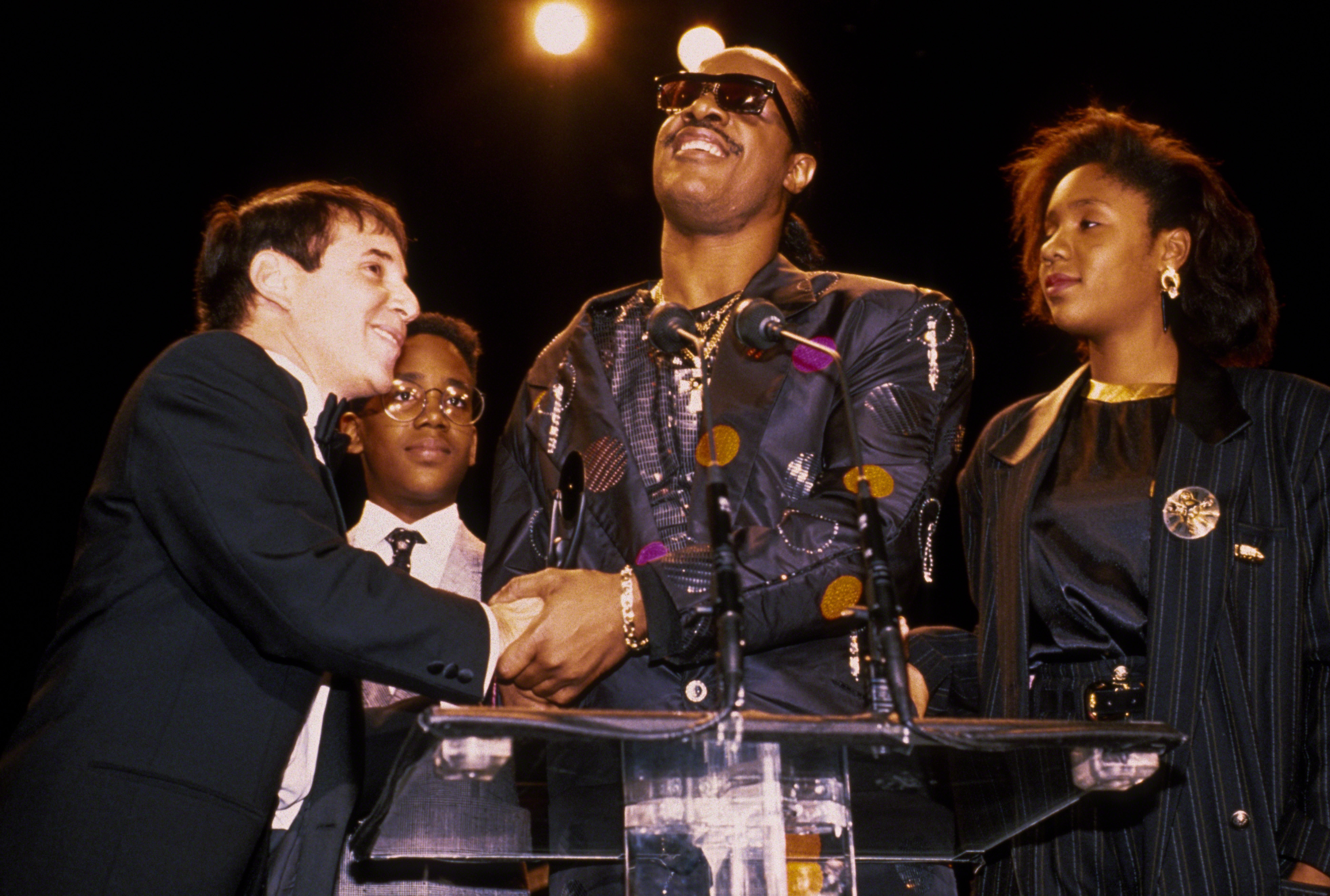 Paul Simon, Keita and Stevie Wonder, and Aisha Morris at the 1989 Rock N Roll Hall of Fame Induction Ceremony on January 1, 1989, in New York City. | Source: Getty Images