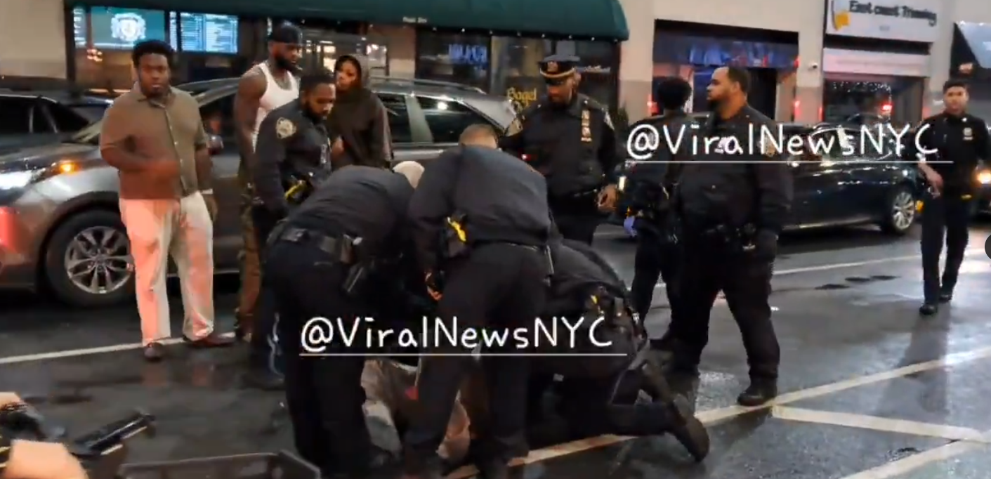 Police officers and bystanders are gathered on the street where Kris Boyd was shot, posted on November 16, 2025. | Source: X/@ViralNewsNYC