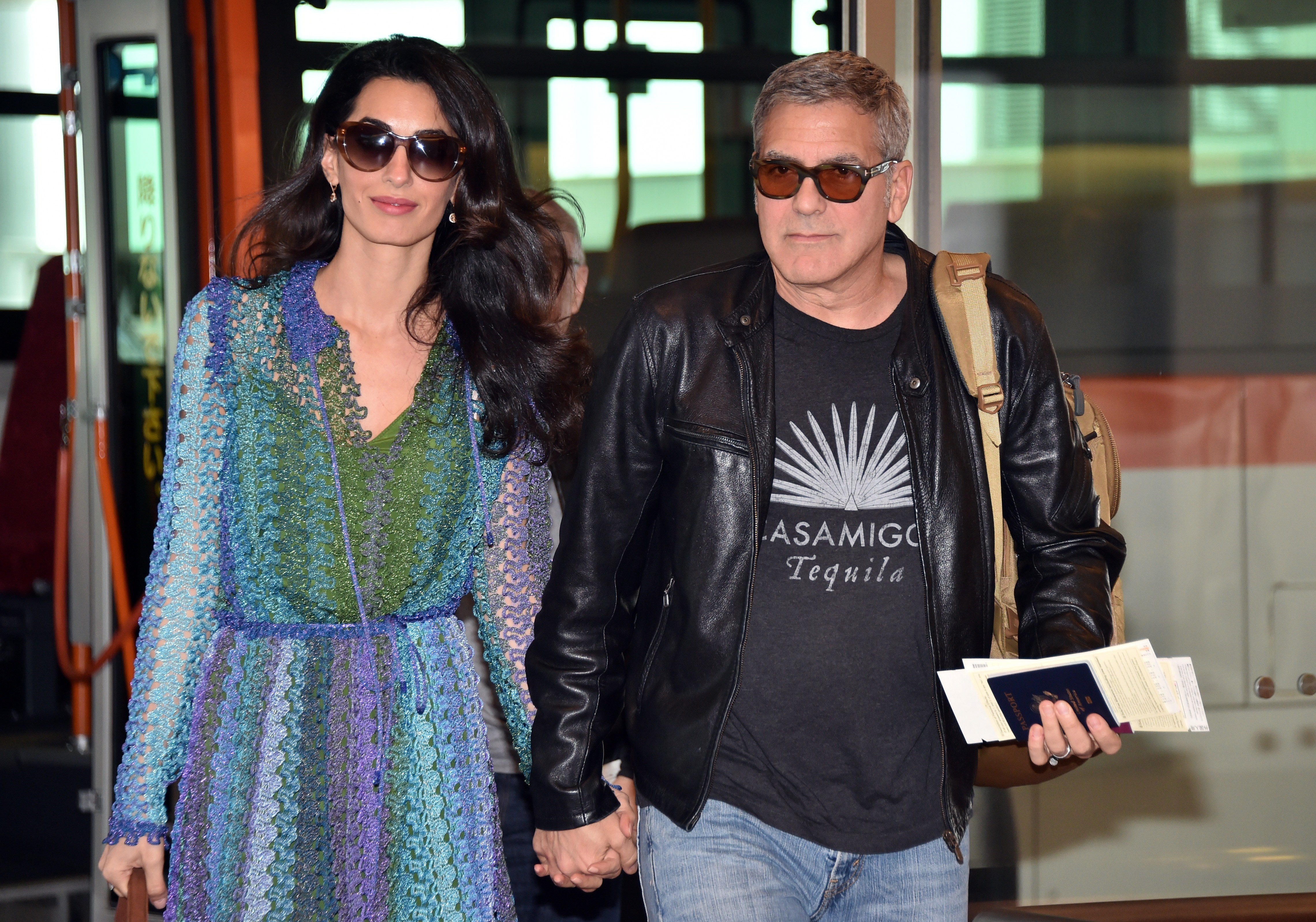 George Clooney (R), accompanied by his wife Amal (L), arrives at Haneda airport in Tokyo on May 24, 2015. | Source: Getty Images