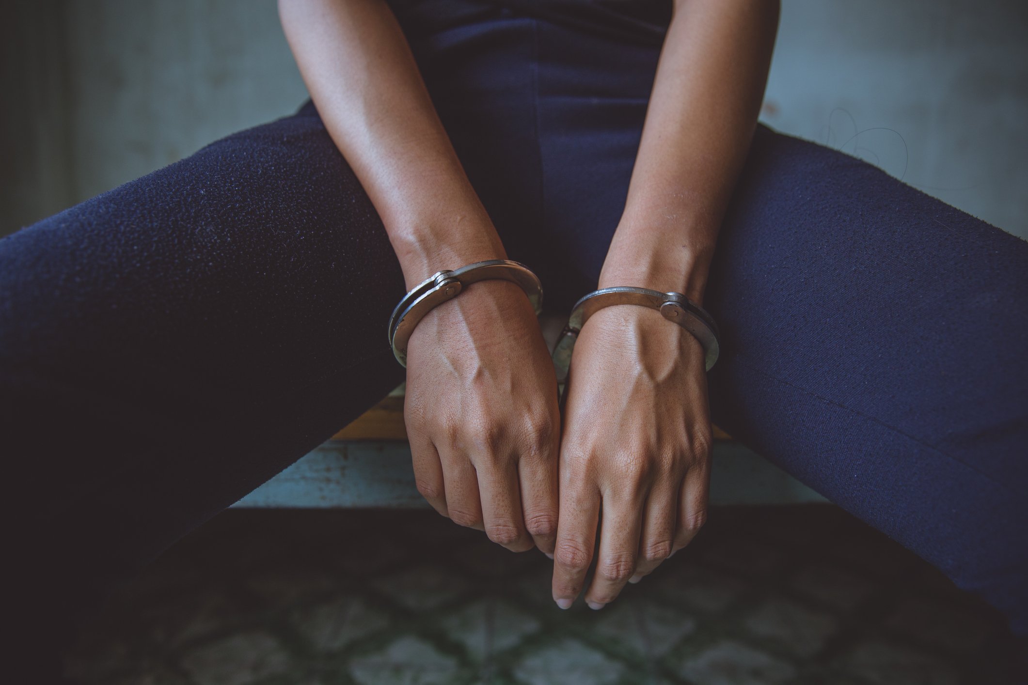 Frau trägt Handschellen im Gefängnis I Quelle: Getty Images