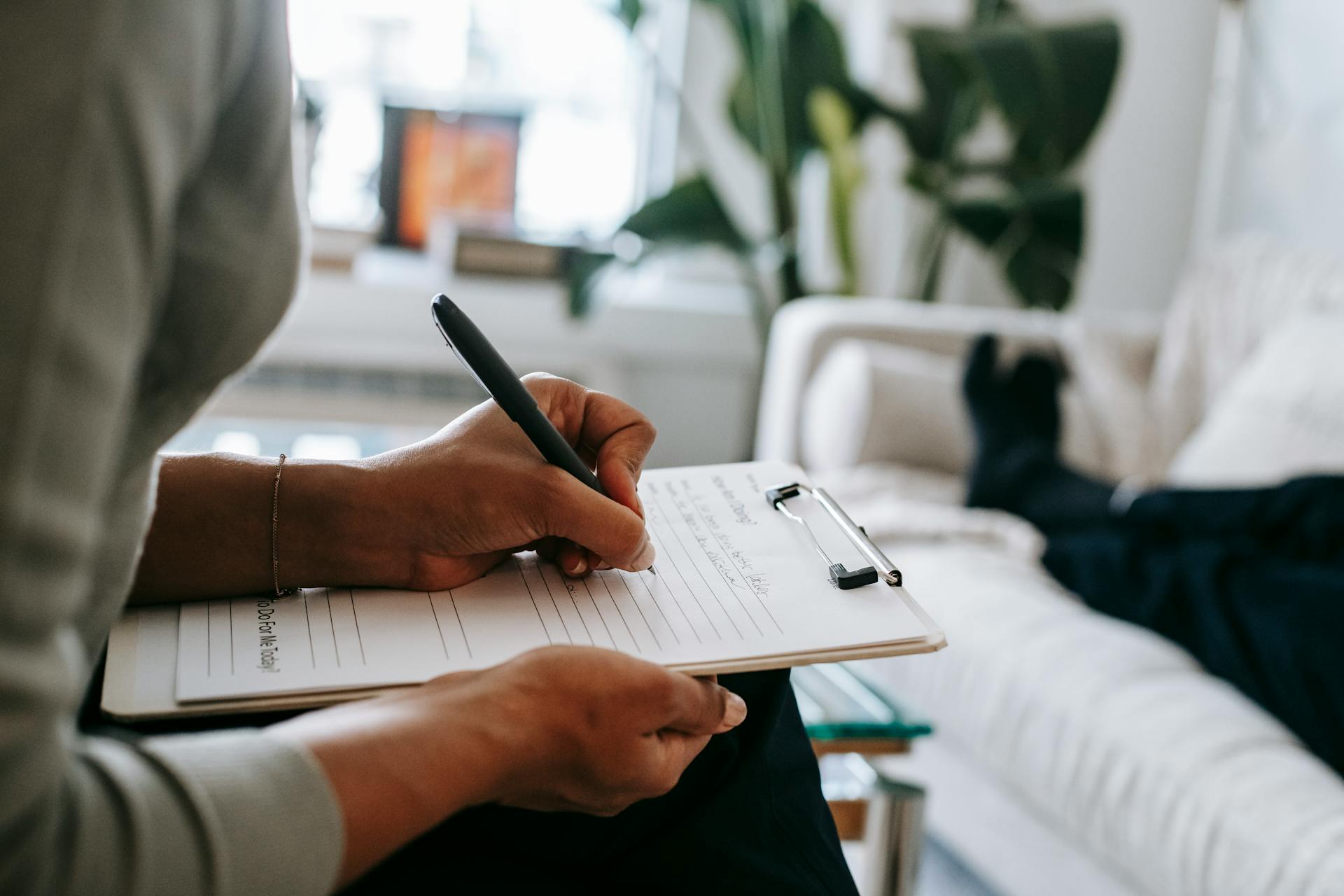 A person writing notes during a therapy session | Source: Pexels