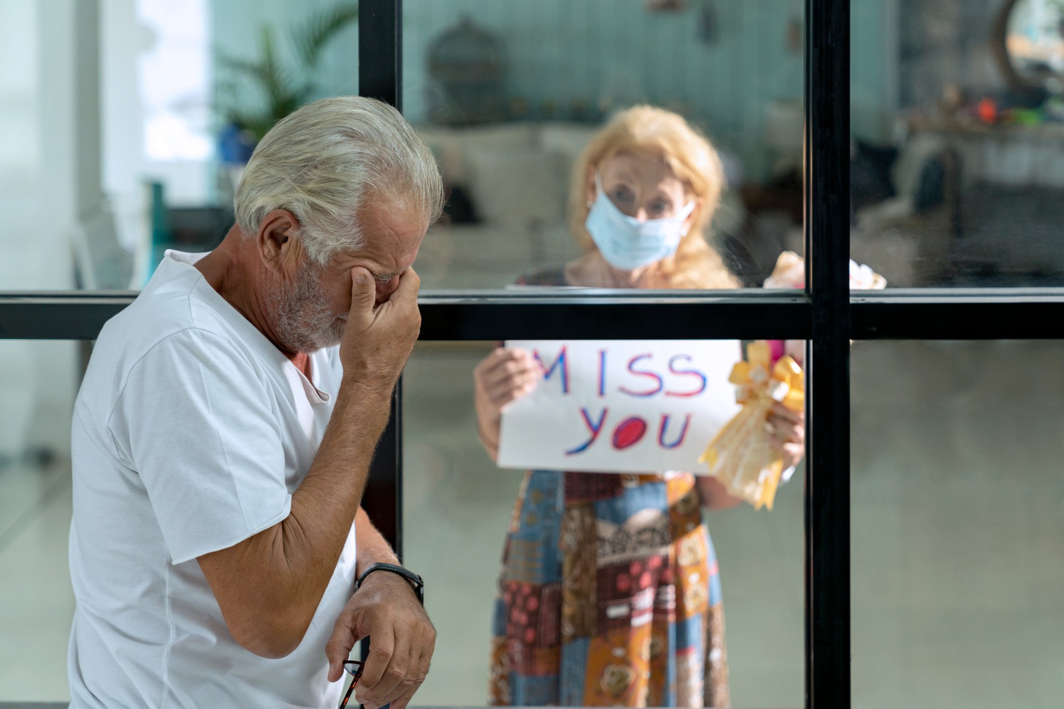 Ältere Frau, die Ehemann in Quarantäne durch Fenster besucht | Quelle: Getty Images