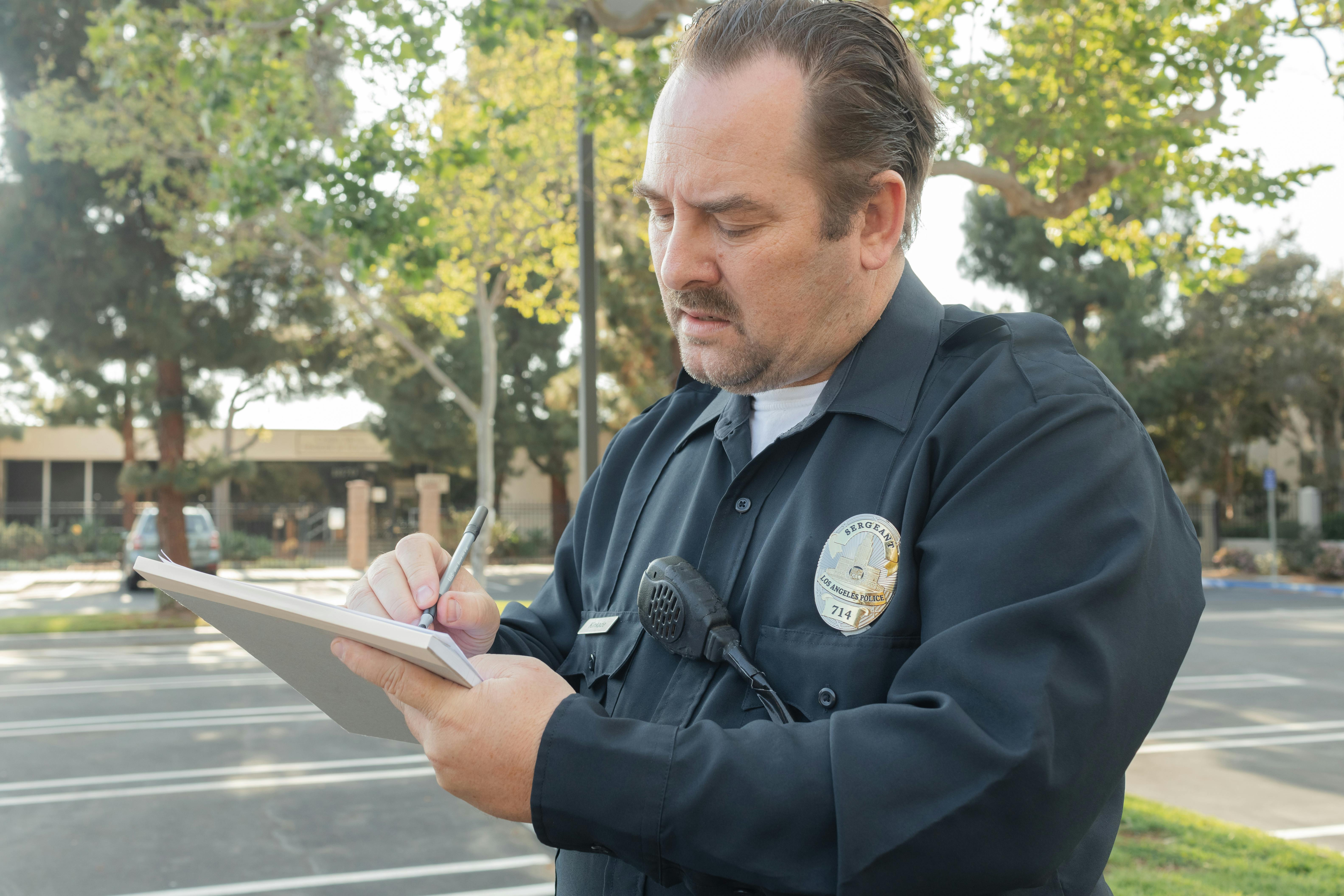 A cop writing down something in his notepad | Source: Pexels