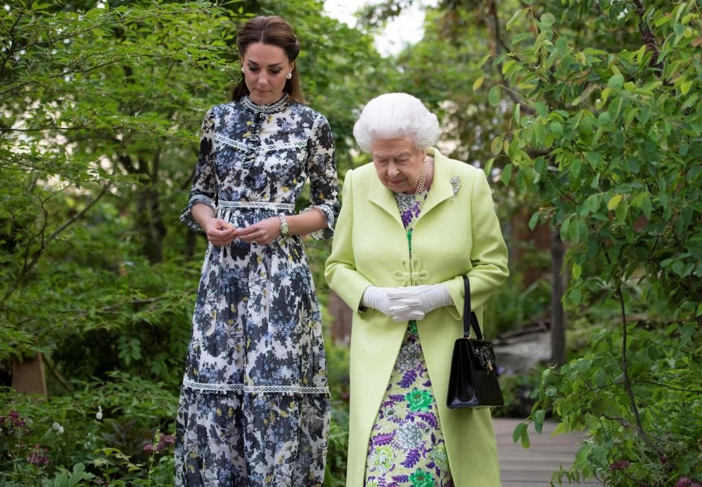 Britain's Catherine, Duchess of Cambridge (L) shows Britain's Queen Elizabeth II during their visit to the 2019 RHS Chelsea Flower Show in London on May 20, 2019. | Source: Getty Images