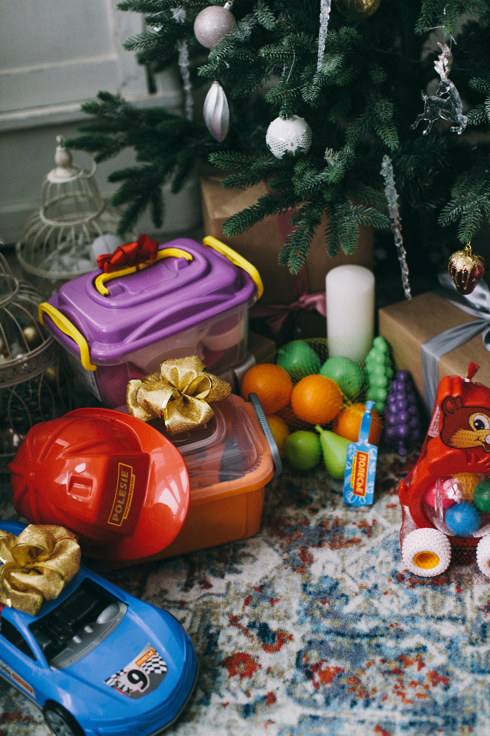 Children's toys placed under a Christmas tree | Source: Pexels