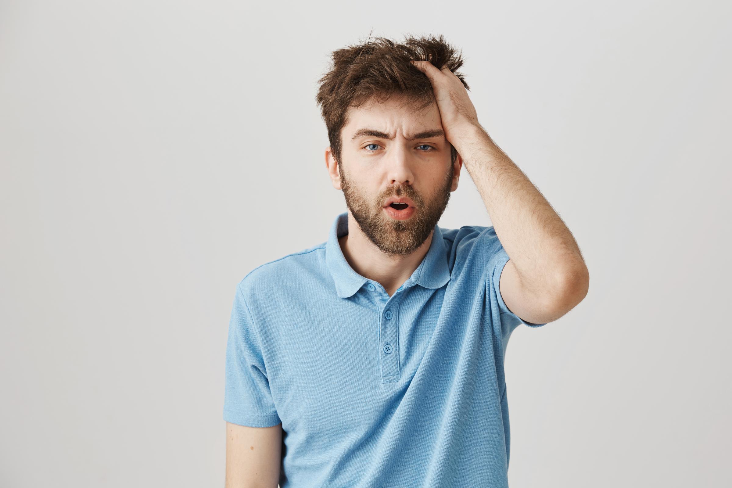 A frustrated man holding his head | Source: Freepik