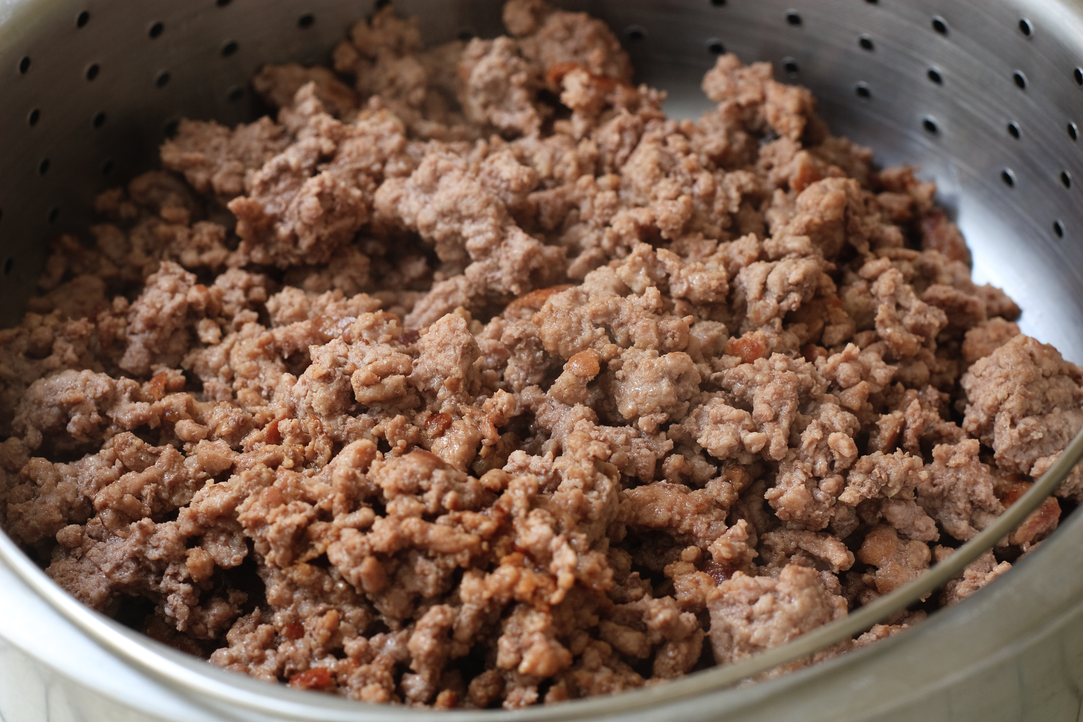 Cooked ground beef on a strainer | Source: Getty Images