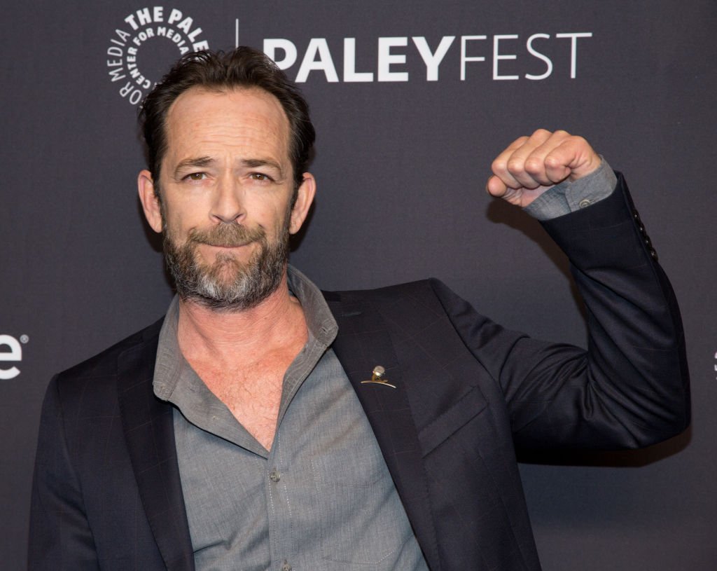 Luke Perry throws a fist in the air as he arrivesd for the 2018 PaleyFest at Dolby Theatre on March 25, 2018, in Hollywood, California | Source: Getty Images (Photo by Gabriel Olsen/FilmMagic)