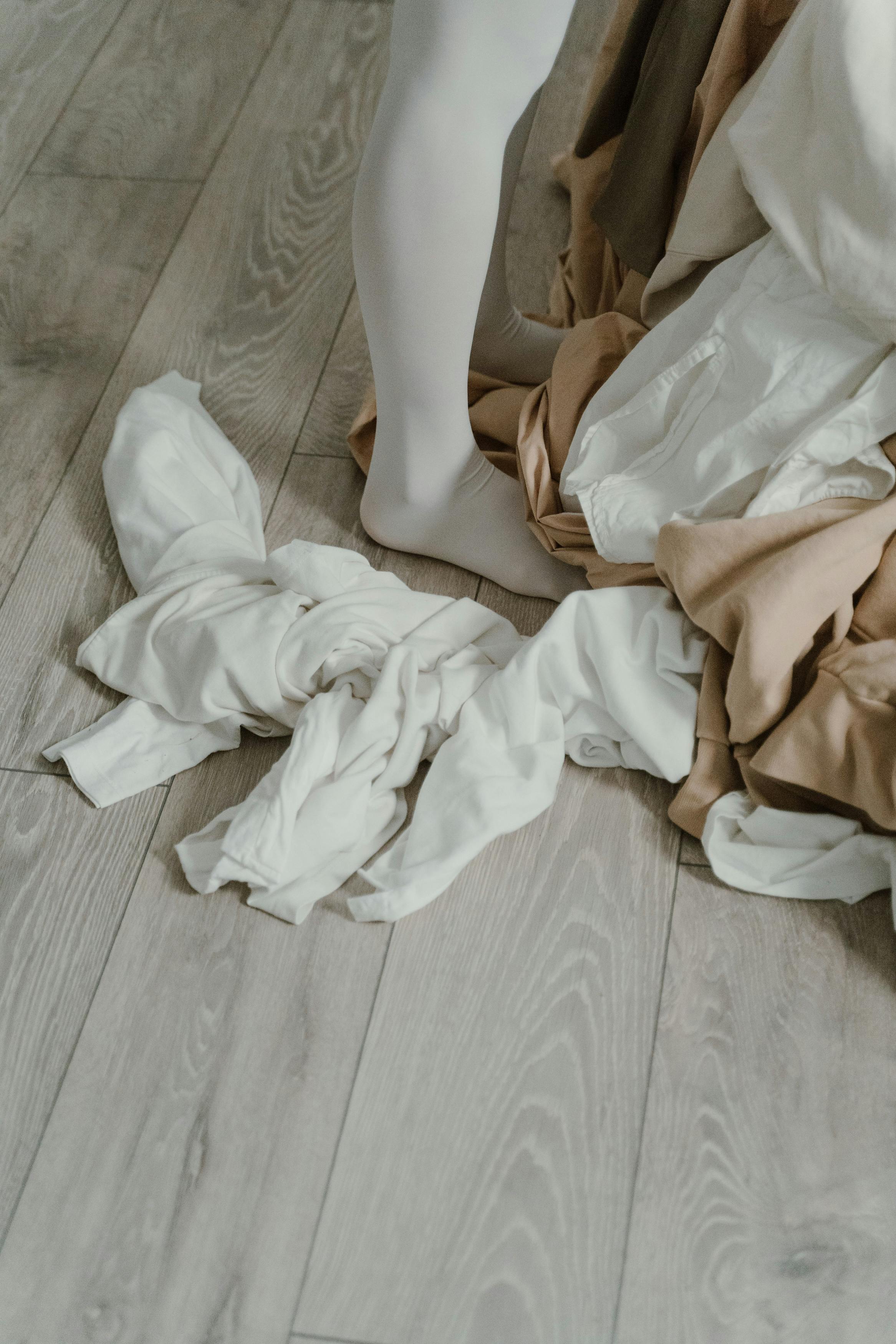 A person standing near clothes strewn across the floor | Source: Pexels