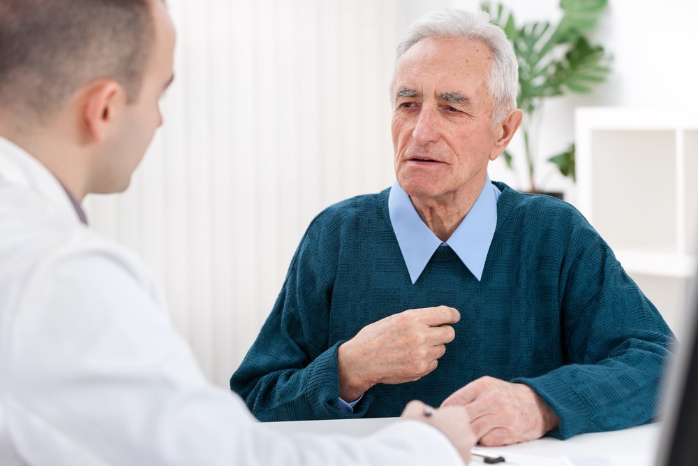 A senior man sitting and discussing with his doctor. | Photo: Shutterstock.