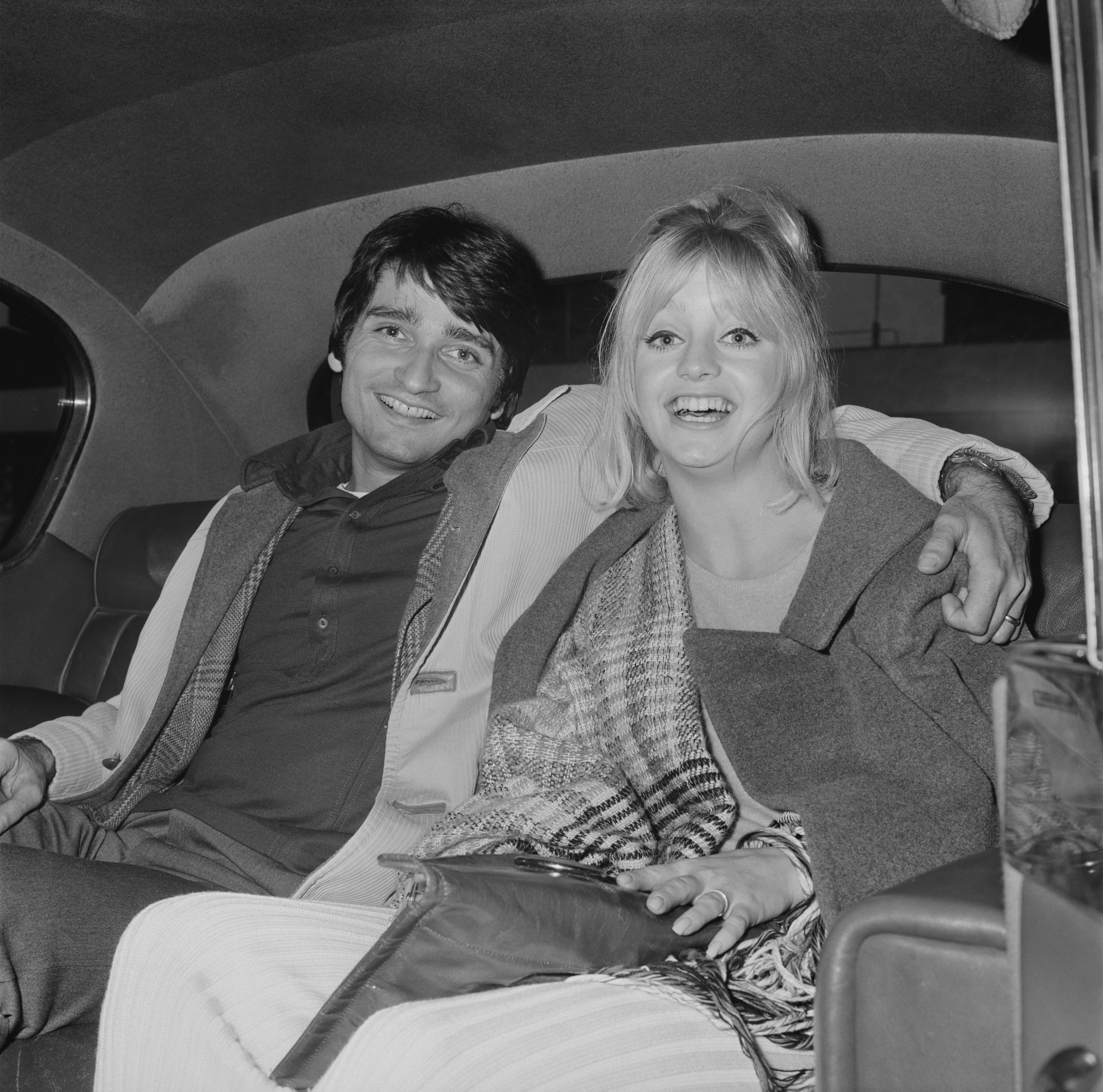 American actress and producer Goldie Hawn with his husband, American actor, dancer, and director Gus Trikonis, sitting in the backseat of a car at Heathrow Airport, London, UK, 23rd March 1970 | Source: Getty Images 