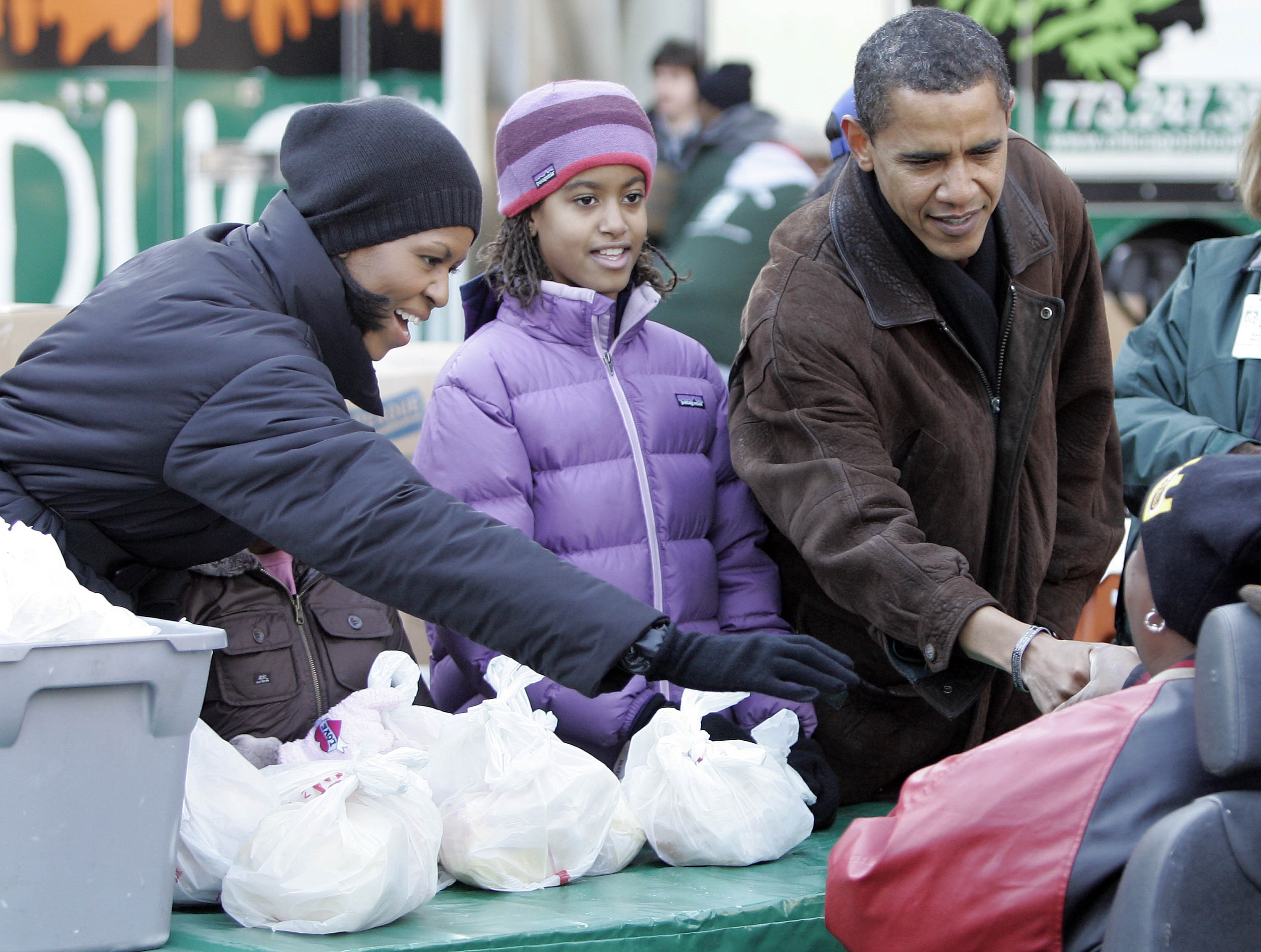 Michelle, Malia, and Barack Obama handing out food at St. Columbanus Parrish and School on November 26, 2008, in Chicago, Illinois. | Source: Getty Images