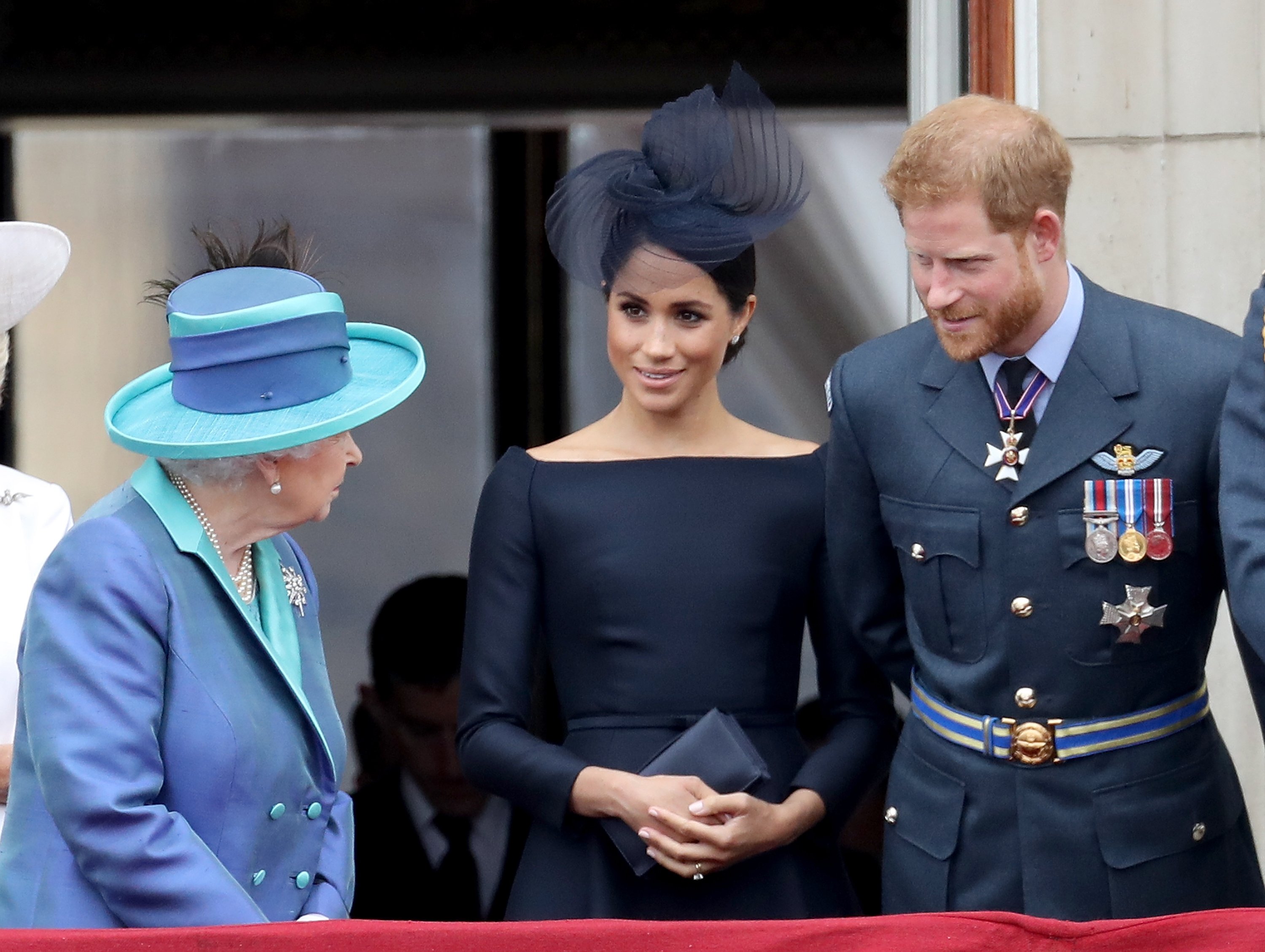 Queen Elizabeth II, Meghan, and Prince Harry, on the balcony of Buckingham Palace, on July 10, 2018 in London, England.  | Source: Getty Images