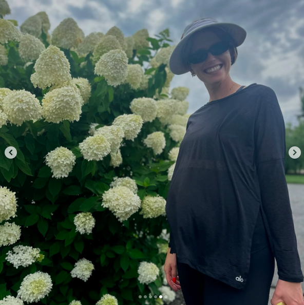 Katherine Schwarzenegger smiling while standing next to flowers. | Source: Instagram/prattprattpratt