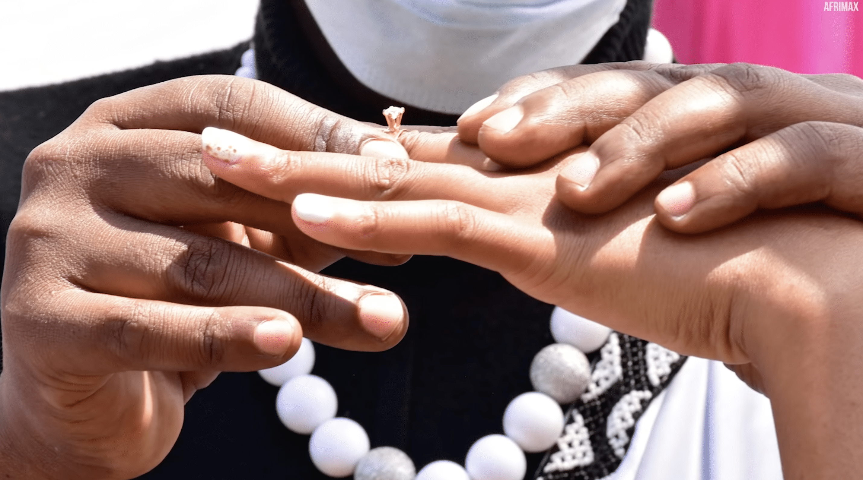 Ndayisenga puts a ring on Debora's finger on their wedding day. | Photo: YouTube.com/Afrimax English