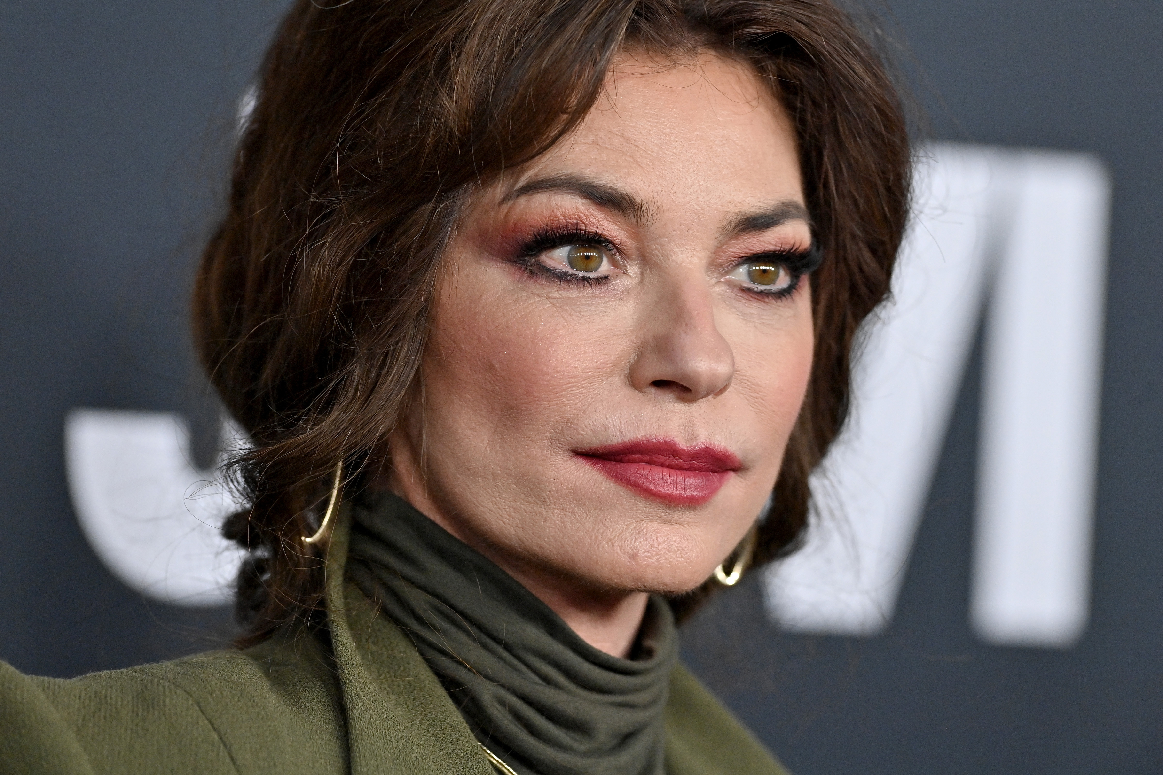 Posing on the carpet at the 2024 MusiCares benefit gala, a stunning Shania Twain complemented her monochromatic jacket look with warm pink-toned eye shadow and subtle gold jewelry. | Source: Getty Images