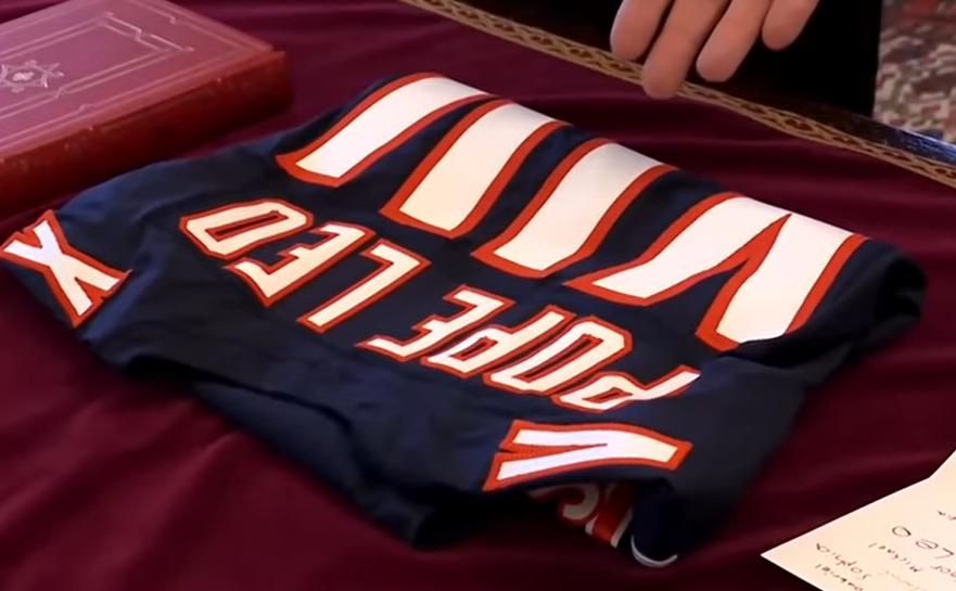U.S. Vice President J. D. Vance presents Pope Leo XIV with a custom Chicago Bears football jersey on May 19, 2025 | Source: YouTube/@diarioas