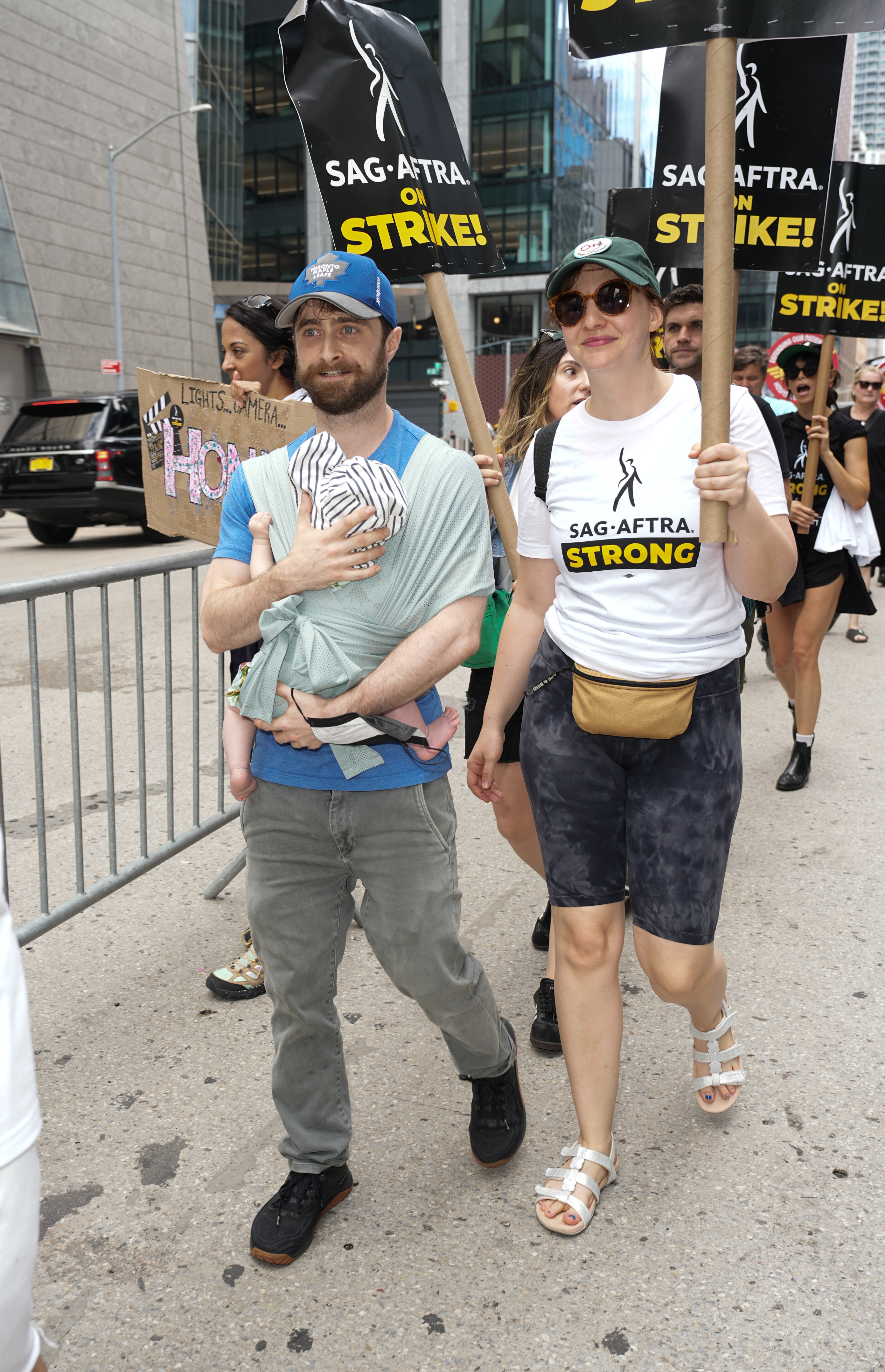 Daniel Radcliffe, his son, and Erin Darke join the picket line in New York City on July 21, 2023 | Source: Getty Images