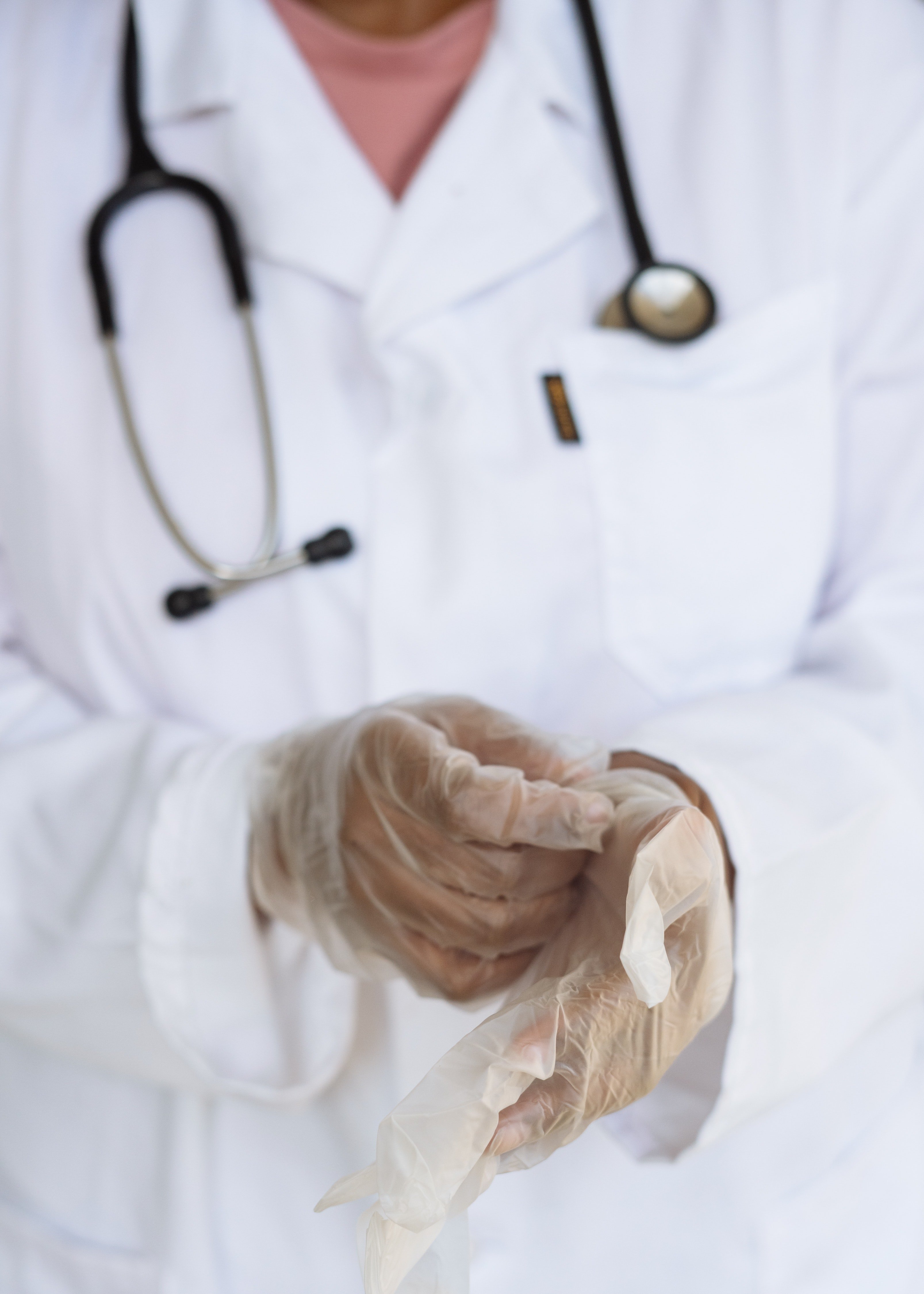 Doctor quitándose guantes de látex. | Foto: Pexels