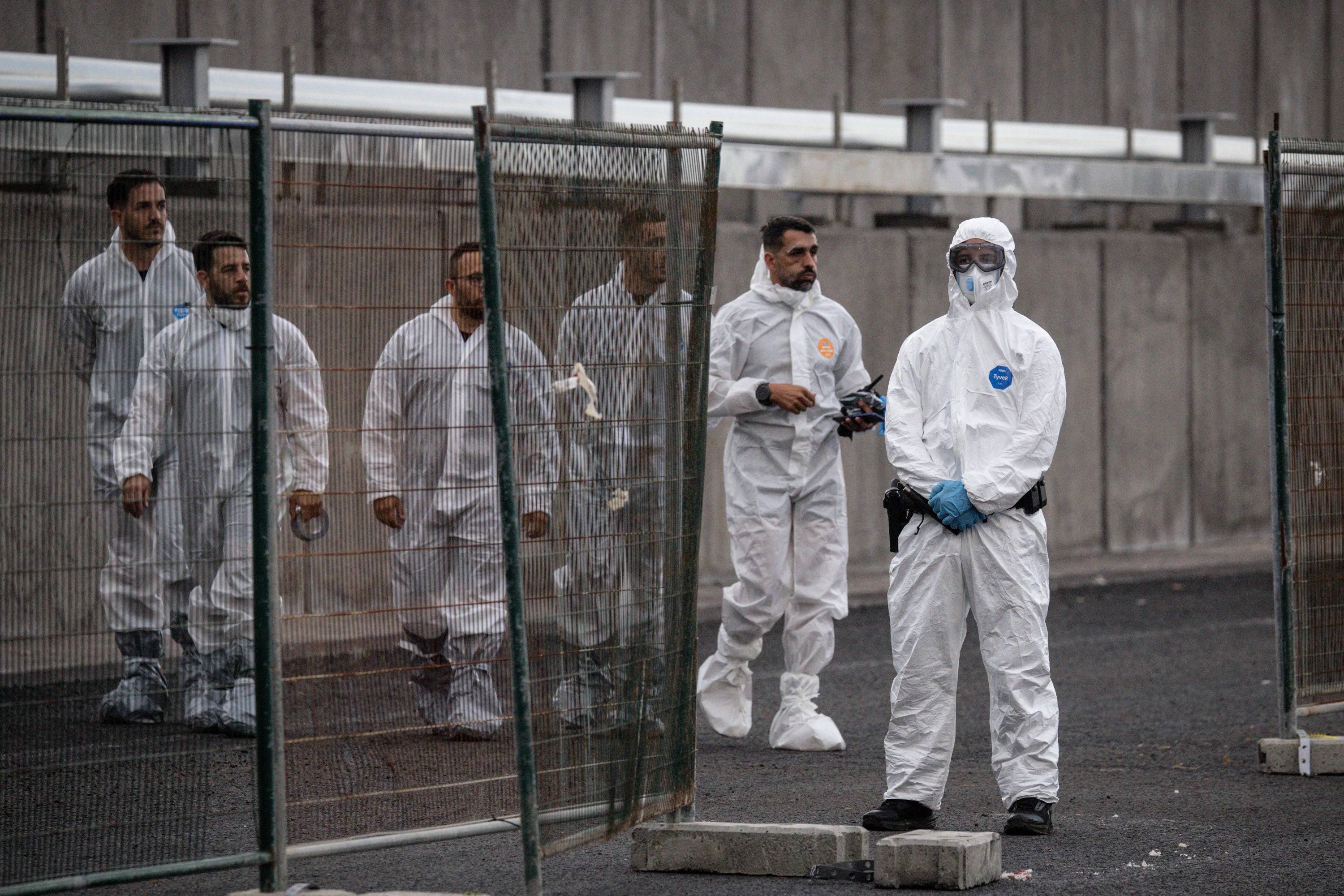 Workers arrive wearing protective clothing after the MV Hondius docked in the Granadilla Port on May 10, 2026 in Tenerife, part of the Canary Islands, Spain. | Source: Getty Images