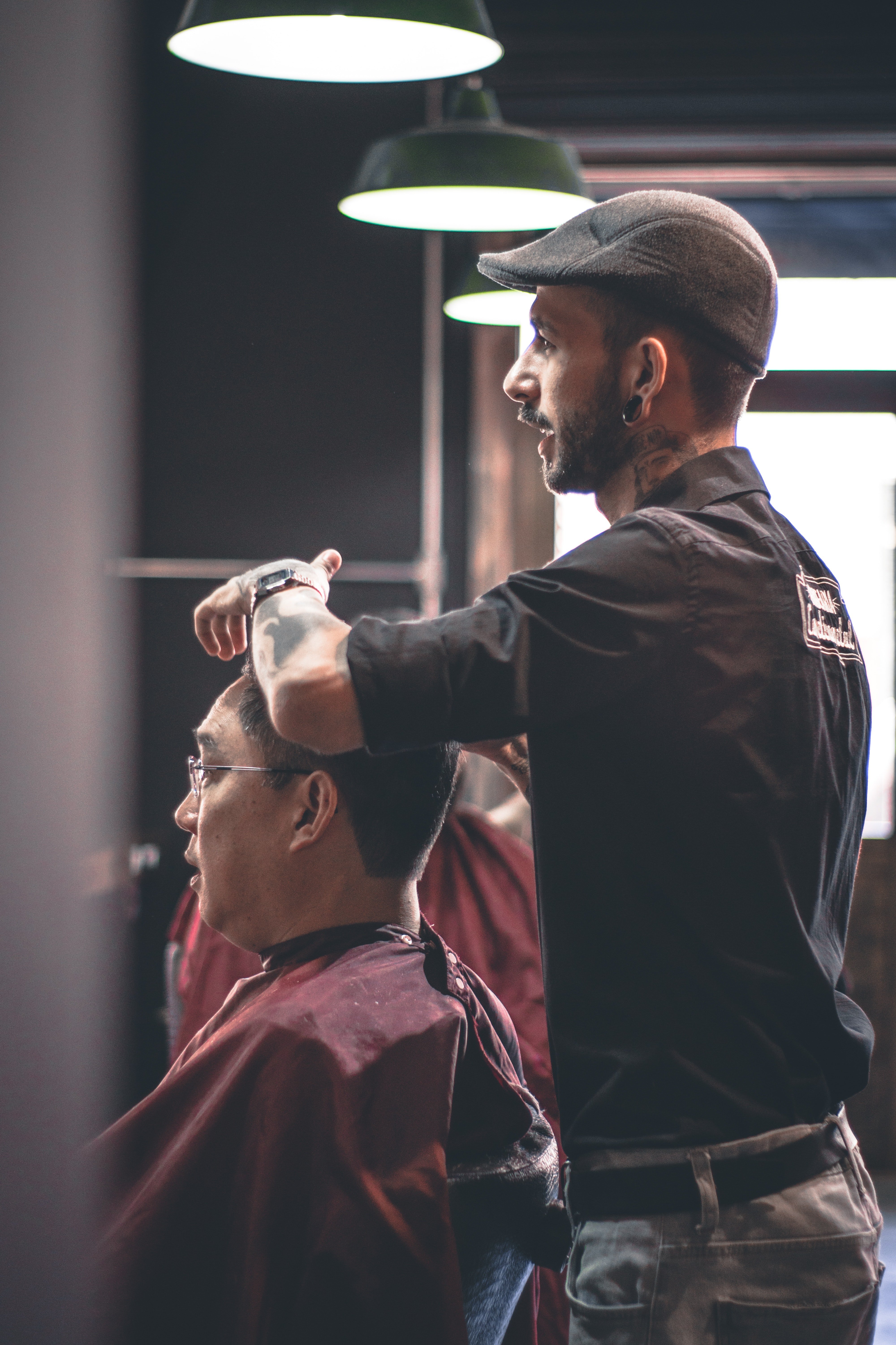 A barber giving a haircut to a man. | Photo: Pexels/Kaique Rocha 
