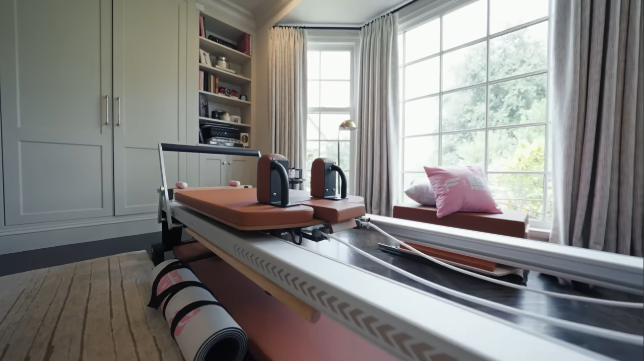 A closer look at Palmer's high-end workout setup, complete with custom pink accent pillows to keep her fitness space feeling totally on-brand. | Source: YouTube/@Archdigest