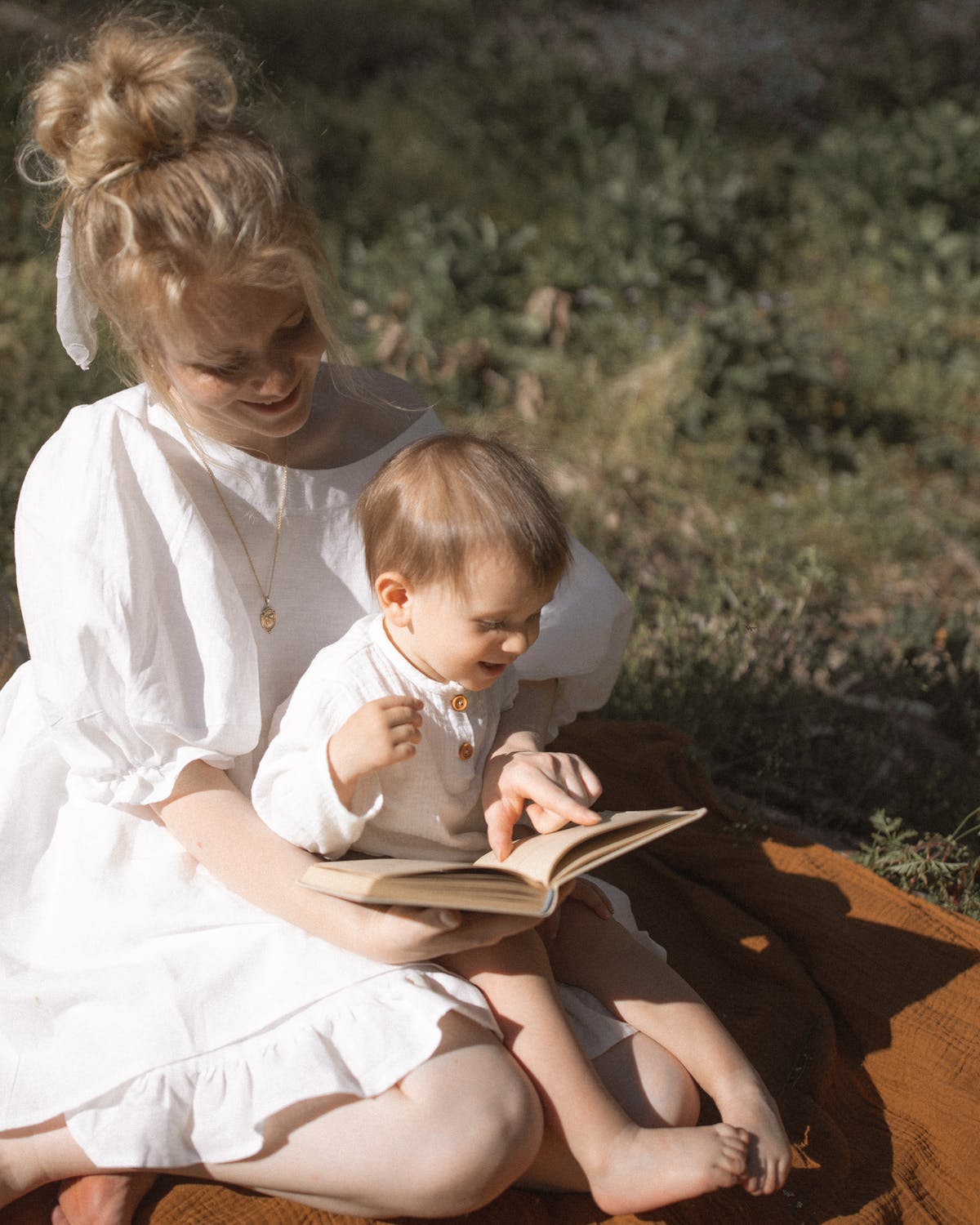 Woman reading a book with a baby girl | Source: Pexels