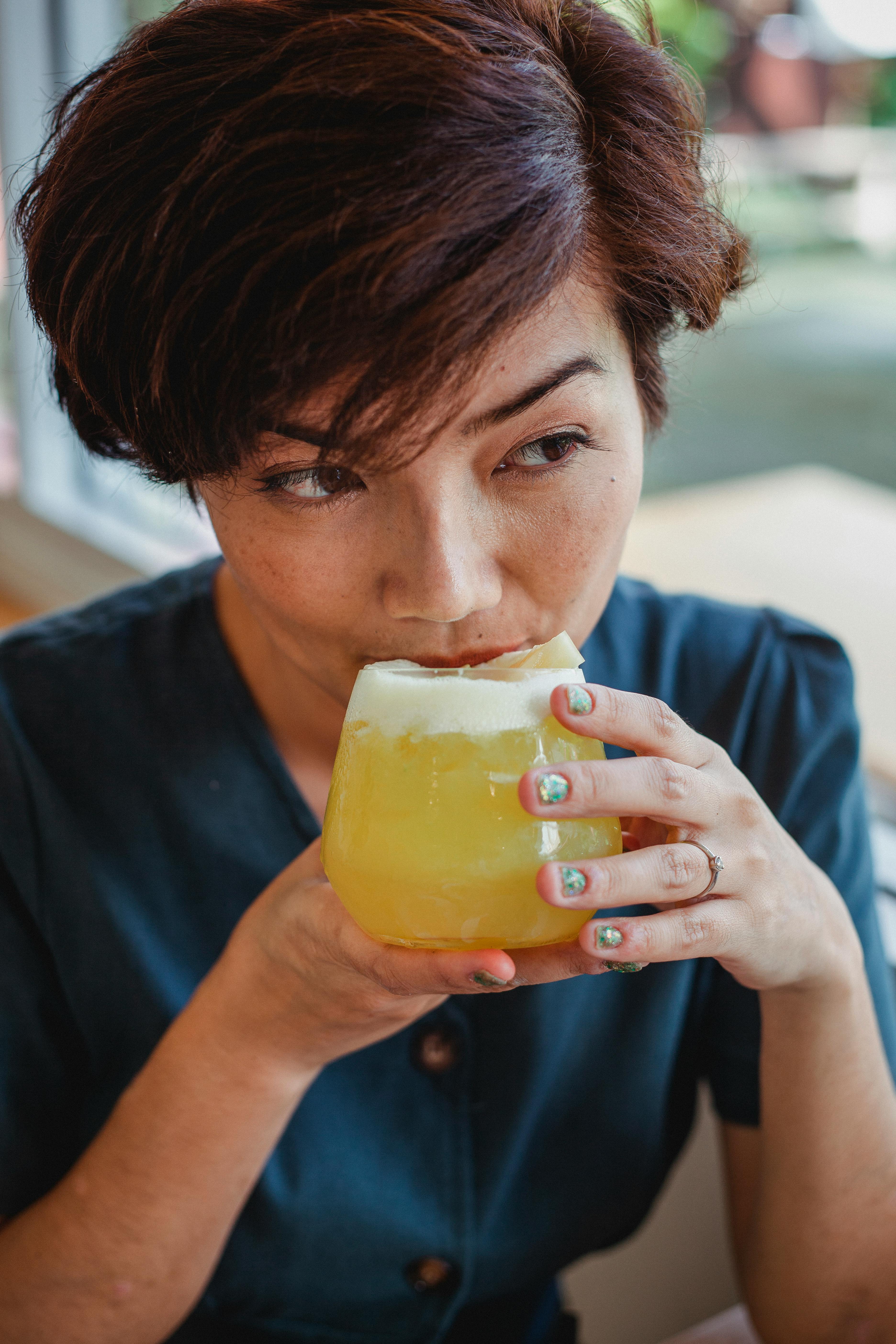 A woman sipping a cocktail | Source: Pexels