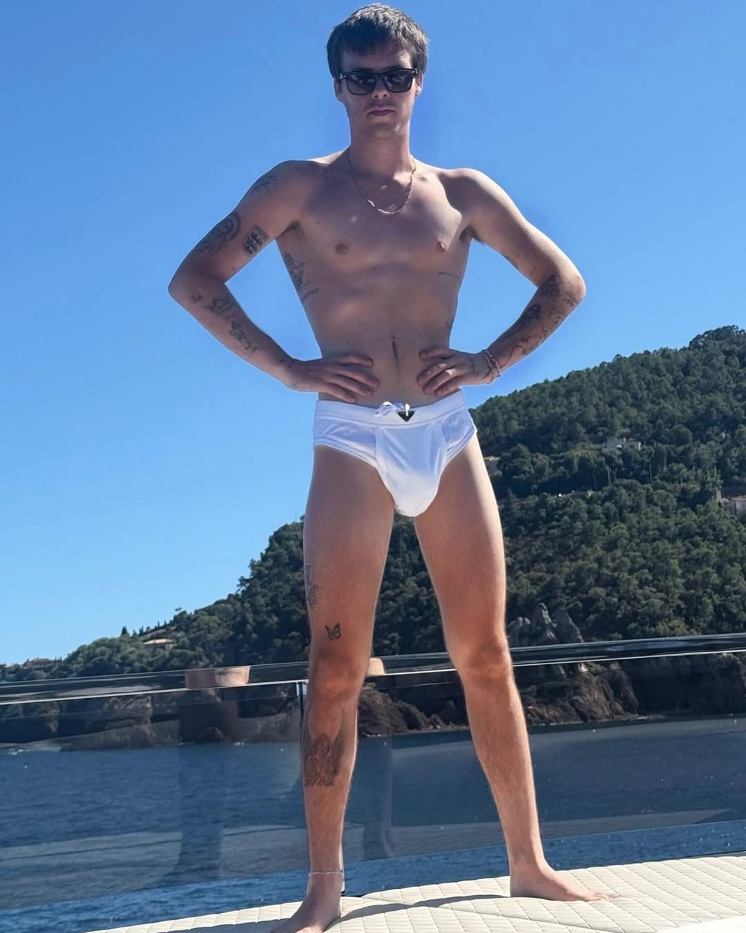 Cruz Beckham standing in a yacht wearing a bathing suit, from Victoria Beckham's vacation post dated August 10, 2025 | Source: Instagram/victoriabeckham