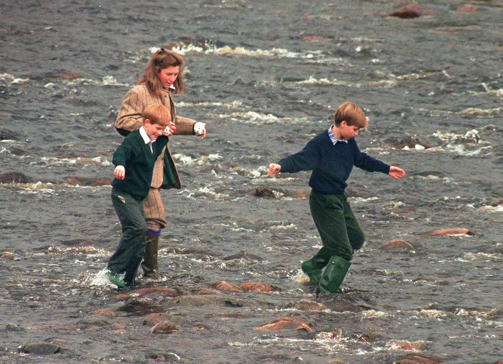 Royal Nanny, Tiggy Legge-Bourke, Prince William,and Prince Harry walk in the River Gairn, near the Balmoral Estate on October 22, 1994 in Balmoral, Scotland | Getty Images