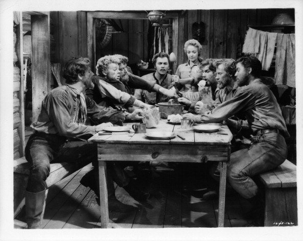 Jane Powell and Howard Keel are amazed at the free for all brawl which always occurs when the rest of the brothers gather around the table in a scene from the film 'Seven Brides For Seven Brothers', 1954 | Photo: Getty Images