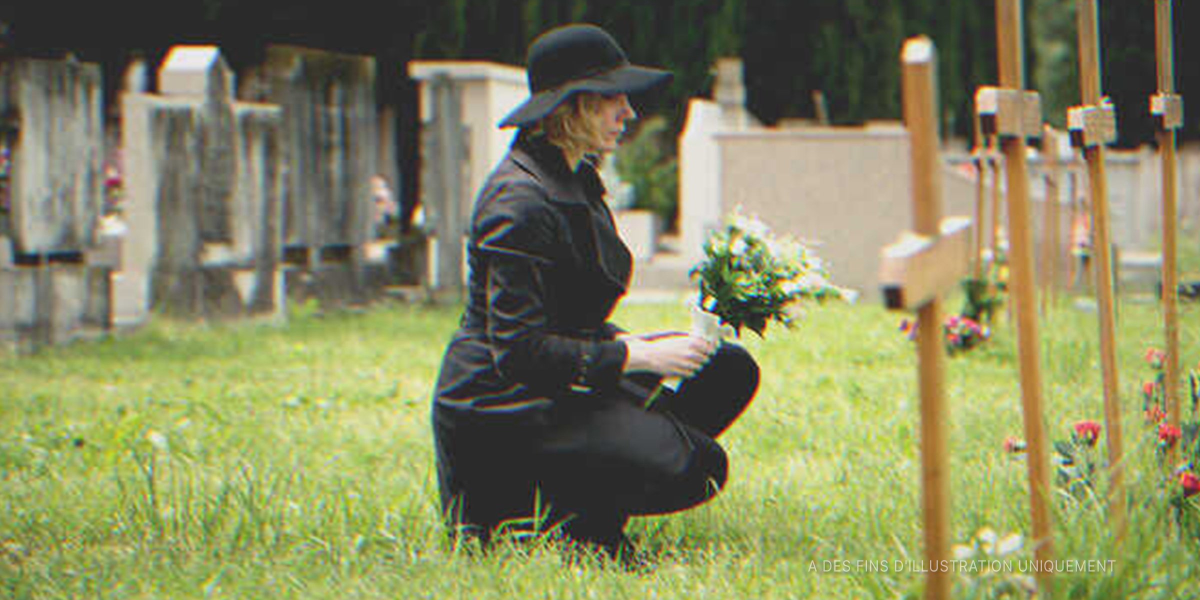 Une femme assise devant une tombe | Photo : Shutterstock