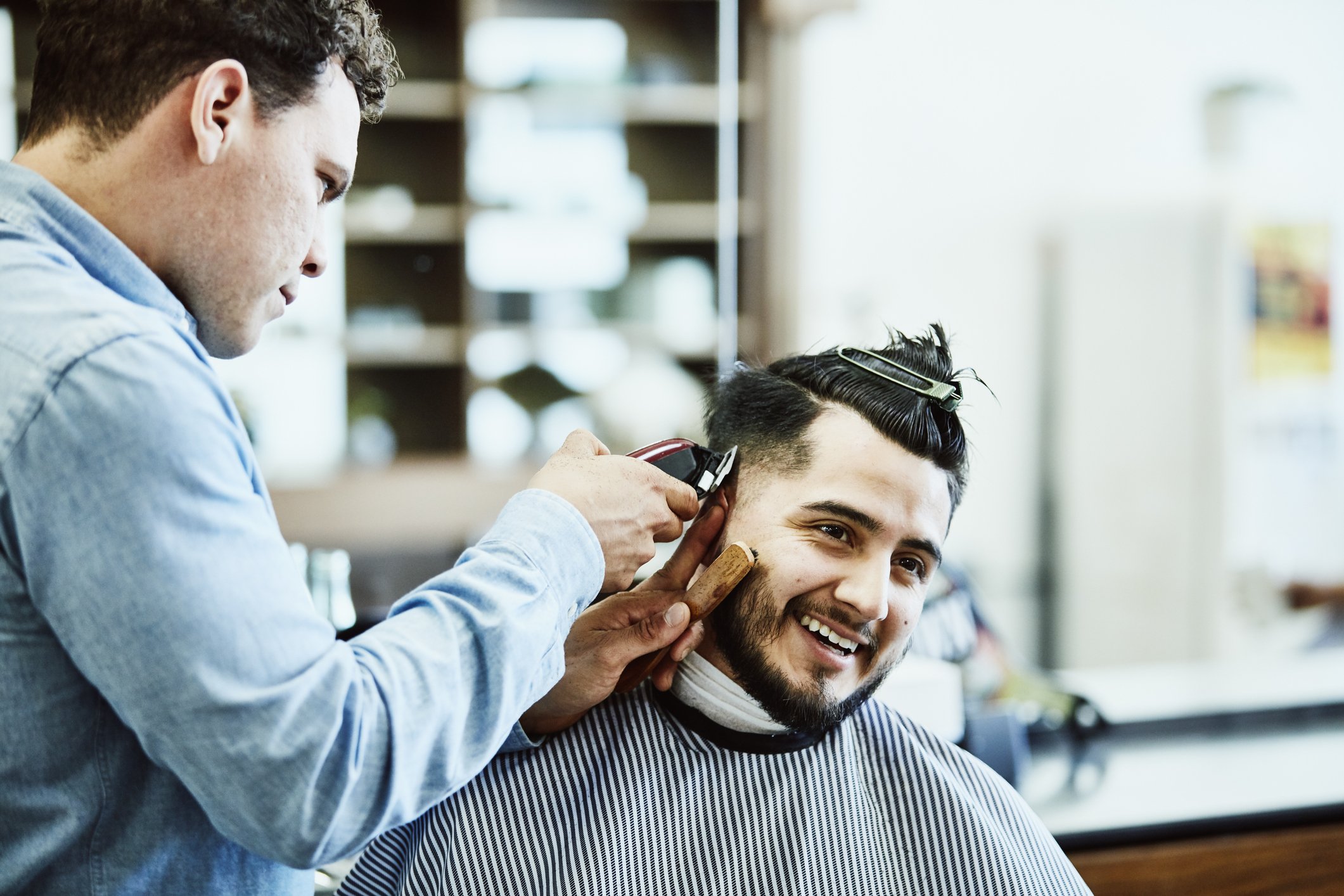 Der lächelnde Mann lässt sich vom Friseur die Haare schneiden. I Quelle: Getty Images