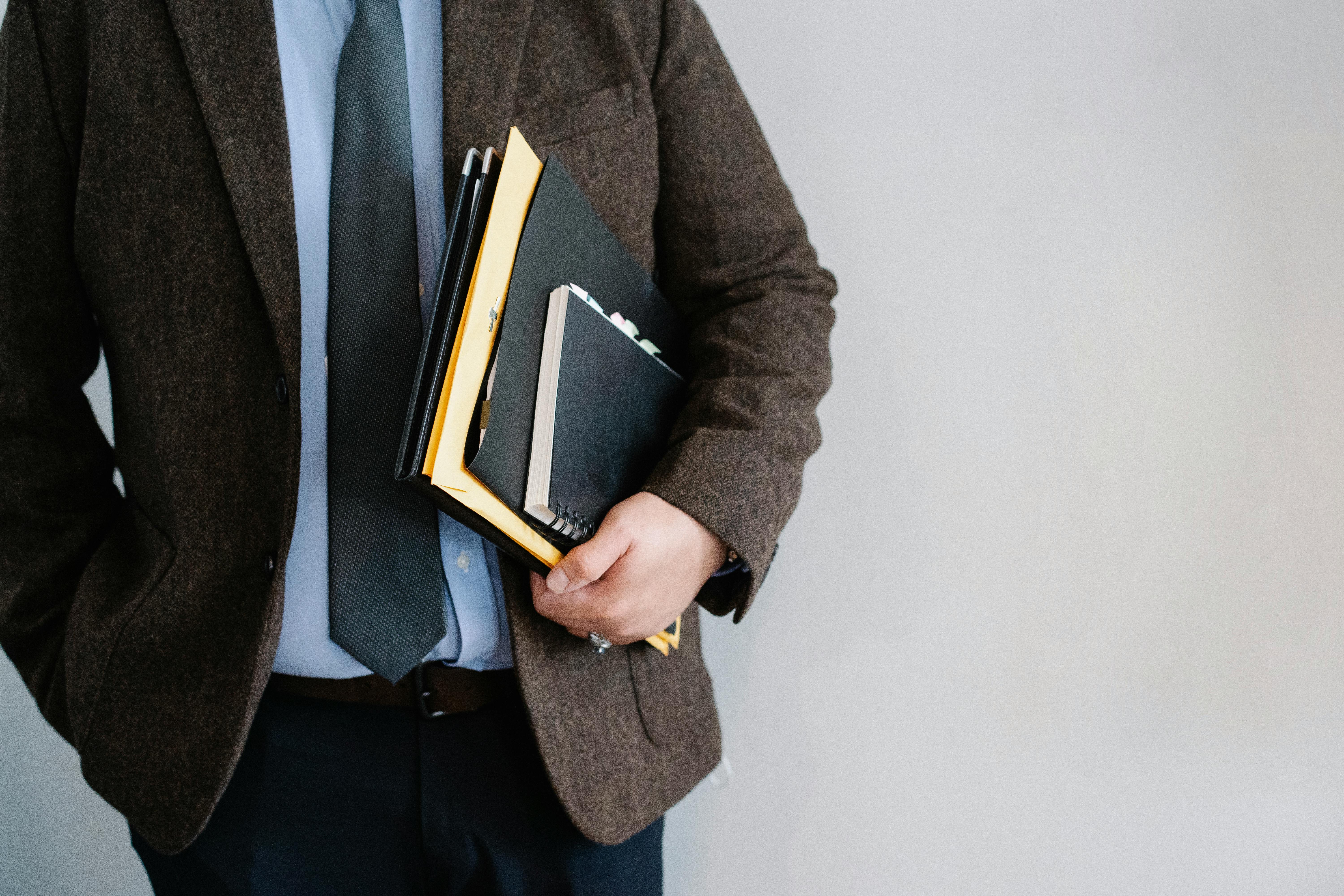 A businessman holding legal documents | Source: Pexels