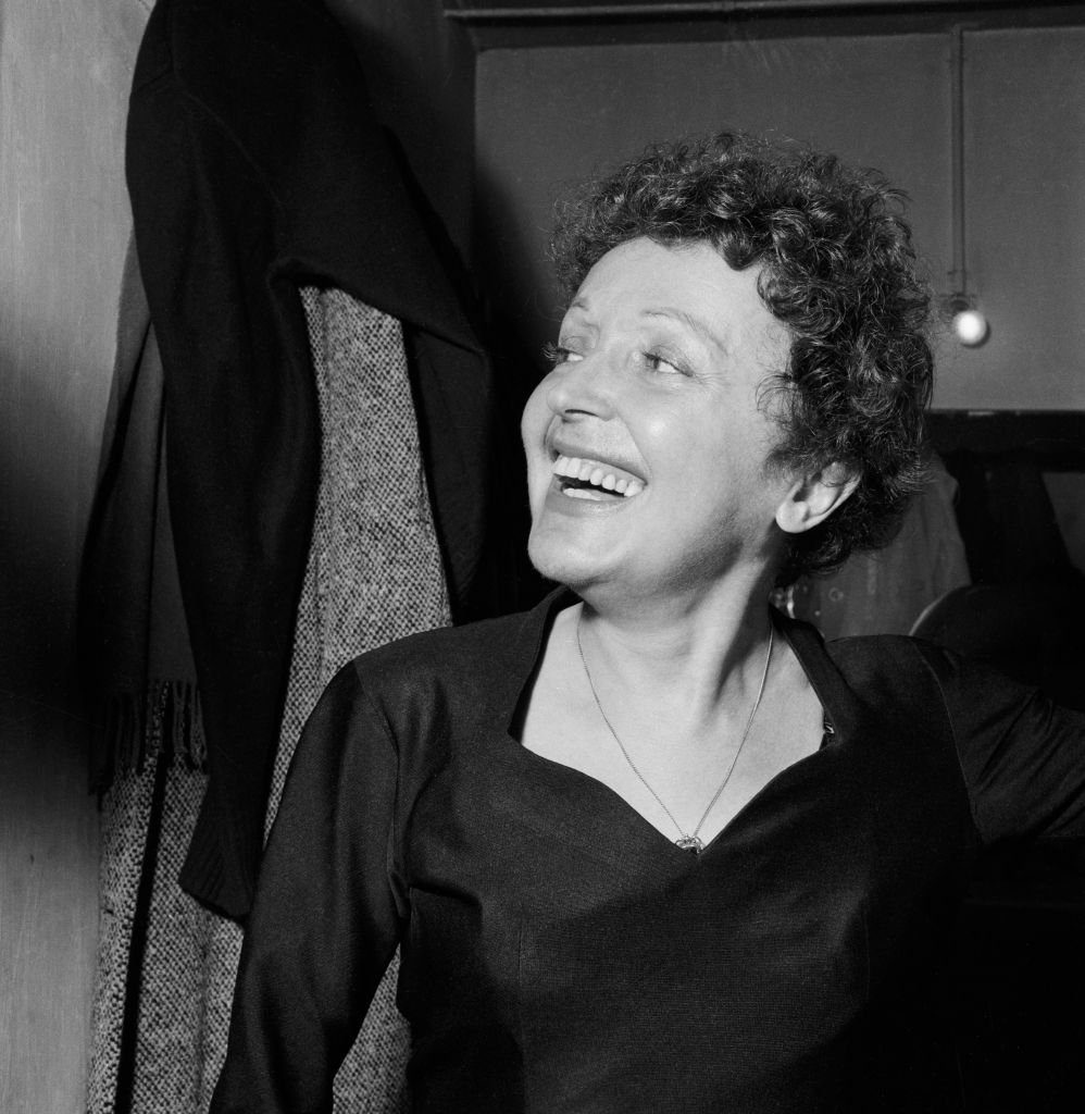 Edith Piaf souriante dans sa loge avant de monter sur scène, à Melun | photo : Getty Images
