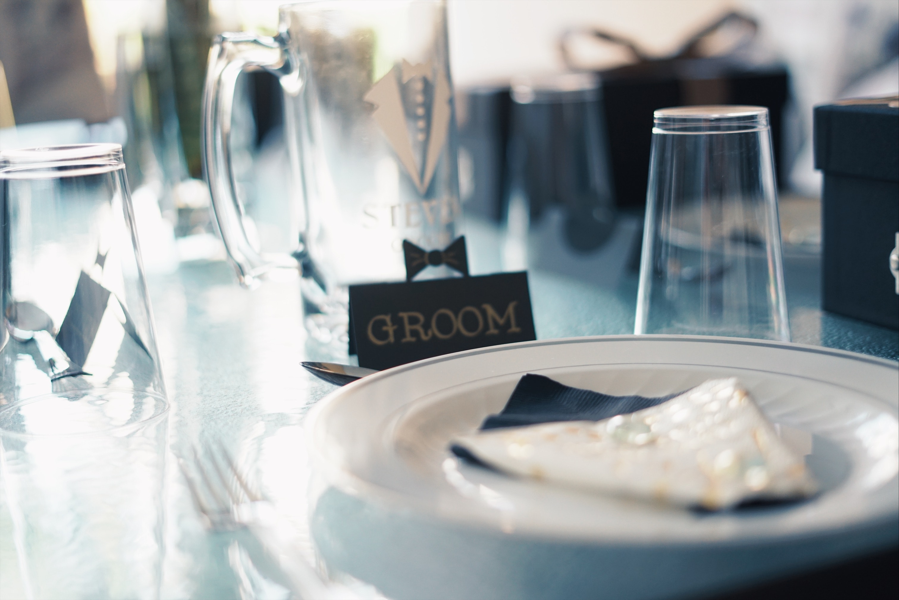 Round white ceramic plate near glass cups and groom sign | Source: Pexels