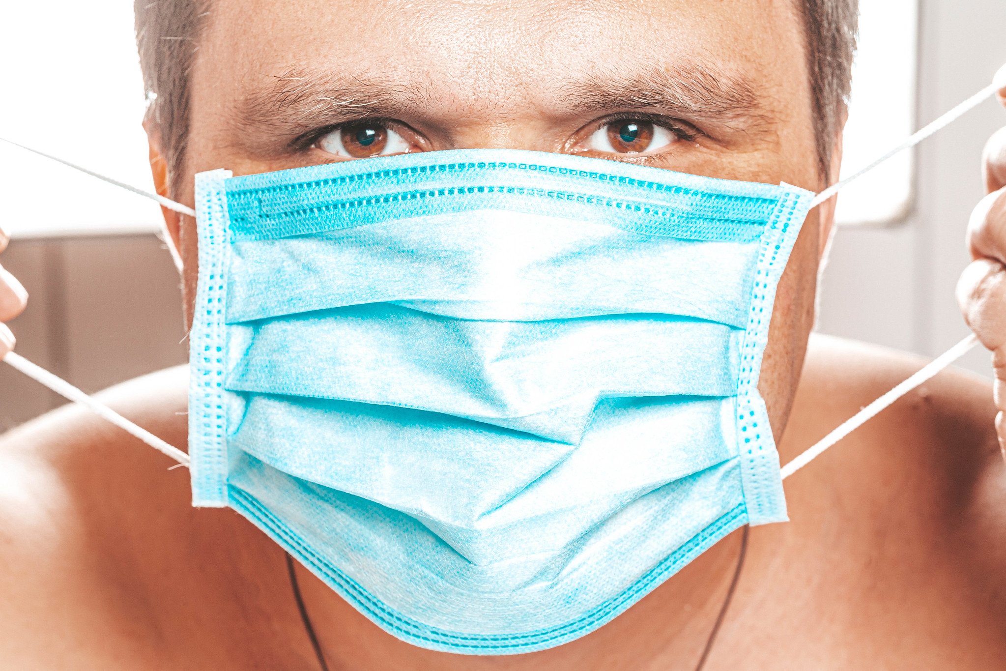 Hombre colocándose una mascarilla médica protectora. | Foto: Flickr