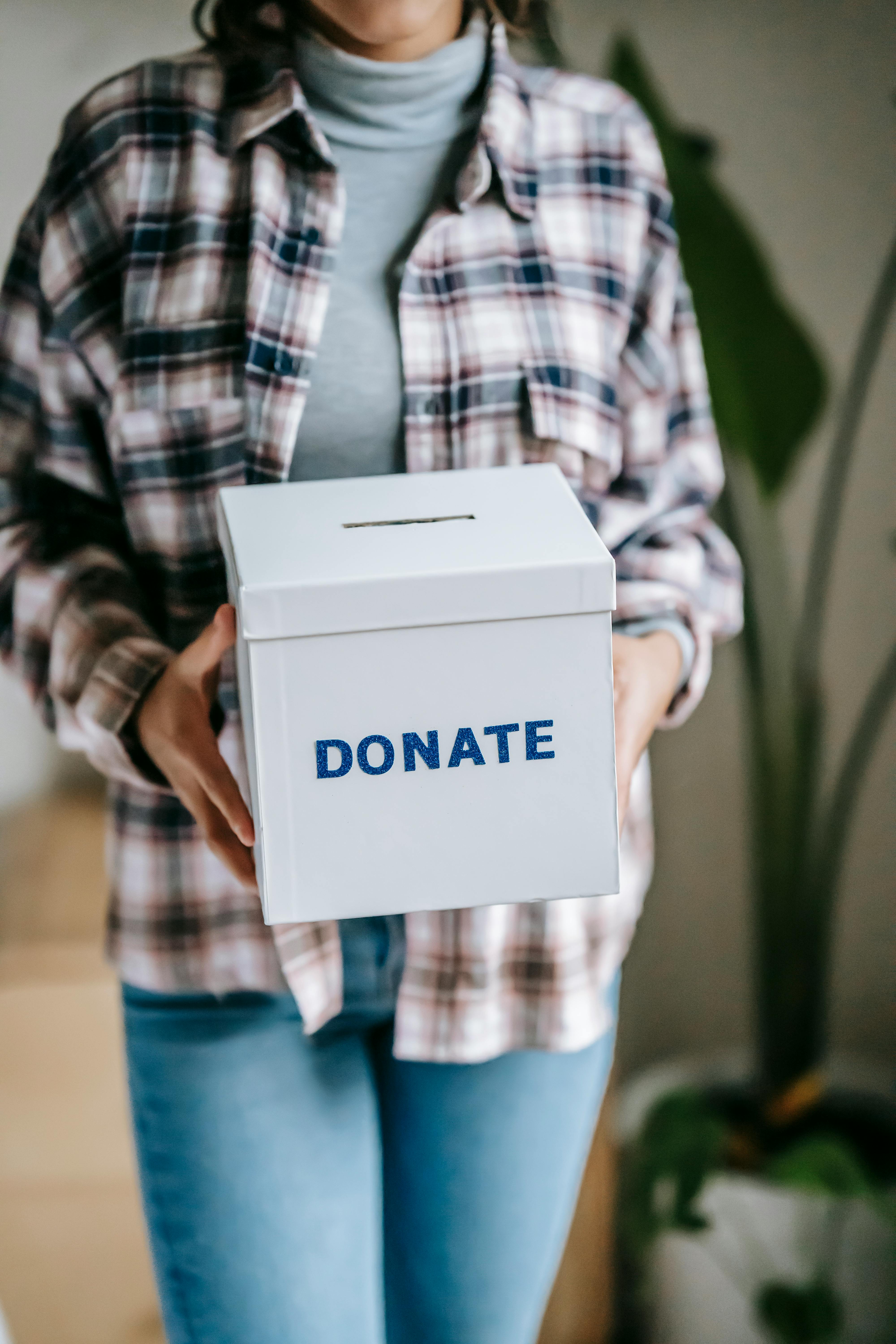 Una mujer sosteniendo una caja que dice "donar" | Fuente: Pexels